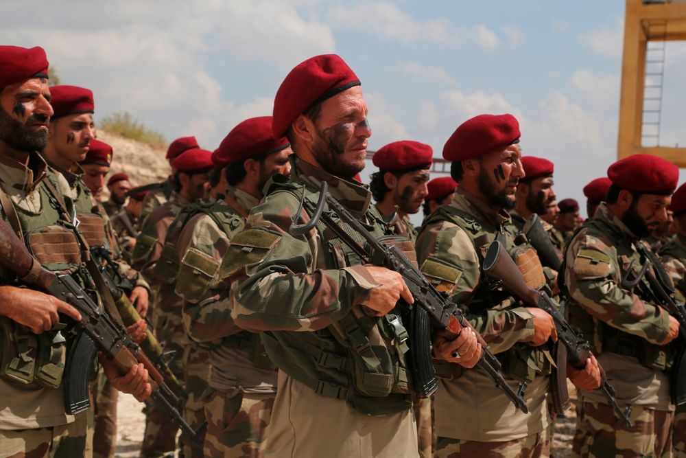 FILE - In this Monday Oct. 7, 2019 file photo, Turkish-backed forces from the Free Syrian Army, stand in formation during military maneuvers in preparation for a Turkish incursion targeting Syrian Kurdish fighters, near Azaz town, north Syria. The Turkish trained and funded Syrian forces present themselves as heirs to the uprising against President Bashar Assad. But while they include some Islamist and former rebel factions, a large number are Arab and Turkmen fighters from northern and eastern Syria with an ax to grind against the Kurds and a reputation for violence and looting. (AP Photo, File) FILE - In this Monday Oct. 7, 2019 file photo, Turkish-backed forces from the Free Syrian Army, stand in formation during military maneuvers in preparation for a Turkish incursion targeting Syrian Kurdish fighters, near Azaz town, north Syria. The Turkish trained and funded Syrian forces present themselves as heirs to the uprising against President Bashar Assad. But while they include some Islamist and former rebel factions, a large number are Arab and Turkmen fighters from northern and eastern Syria with an ax to grind against the Kurds and a reputation for violence and looting. (AP Photo, File)