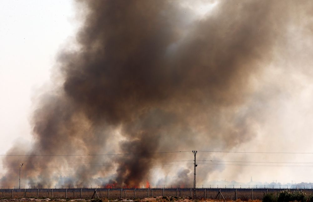 In this photo taken from the Turkish side of the border between Turkey and Syria, in Akcakale, Sanliurfa province, southeastern Turkey, smoke billows from fires on targets in Tel Abyad, Syria, caused by bombardment by Turkish forces, Sunday, Oct. 13, 2019. The United Nations says at least 130,000 people have been displaced by the fighting in northeastern Syria with many more likely on the move as a Turkish offensive in the area enters its fifth day. (AP Photo/Lefteris Pitarakis) In this photo taken from the Turkish side of the border between Turkey and Syria, in Akcakale, Sanliurfa province, southeastern Turkey, smoke billows from fires on targets in Tel Abyad, Syria, caused by bombardment by Turkish forces, Sunday, Oct. 13, 2019. The United Nations says at least 130,000 people have been displaced by the fighting in northeastern Syria with many more likely on the move as a Turkish offensive in the area enters its fifth day. (AP Photo/Lefteris Pitarakis)