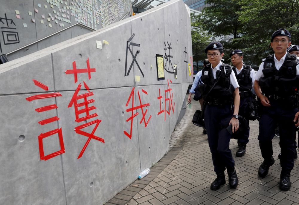 Hong Kong police officers pass by words formed with tape which read Hong Kong police officers pass by words formed with tape which read
