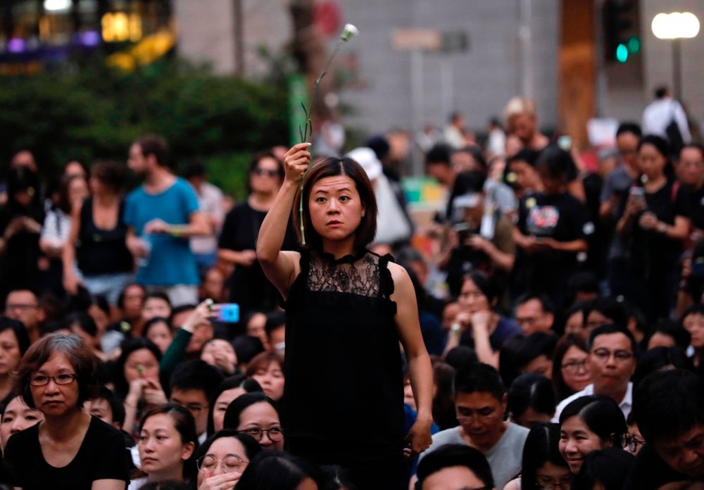 A woman holds a flower as she joins hundreds of mothers protesting against the amendments to the extradition law after Wednesday's violent protest in Hong Kong on Friday, June 14, 2019. Calm appeared to have returned to Hong Kong after days of protests by students and human rights activists opposed to a bill that would allow suspects to be tried in mainland Chinese courts. (AP Photo/Vincent Yu) A woman holds a flower as she joins hundreds of mothers protesting against the amendments to the extradition law after Wednesday's violent protest in Hong Kong on Friday, June 14, 2019. Calm appeared to have returned to Hong Kong after days of protests by students and human rights activists opposed to a bill that would allow suspects to be tried in mainland Chinese courts. (AP Photo/Vincent Yu)