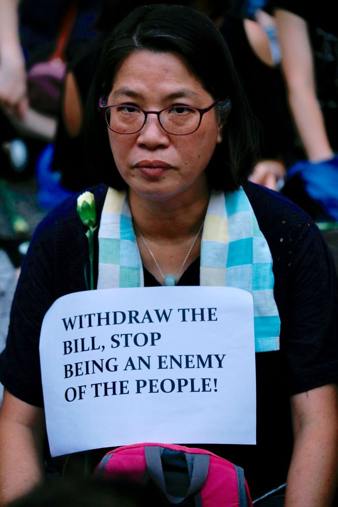 A woman joins hundreds of mothers protesting against the amendments to the extradition law after Wednesday's violent protest in Hong Kong on Friday, June 14, 2019. Calm appeared to have returned to Hong Kong after days of protests by students and human rights activists opposed to a bill that would allow suspects to be tried in mainland Chinese courts. (AP Photo/Vincent Yu) A woman joins hundreds of mothers protesting against the amendments to the extradition law after Wednesday's violent protest in Hong Kong on Friday, June 14, 2019. Calm appeared to have returned to Hong Kong after days of protests by students and human rights activists opposed to a bill that would allow suspects to be tried in mainland Chinese courts. (AP Photo/Vincent Yu)