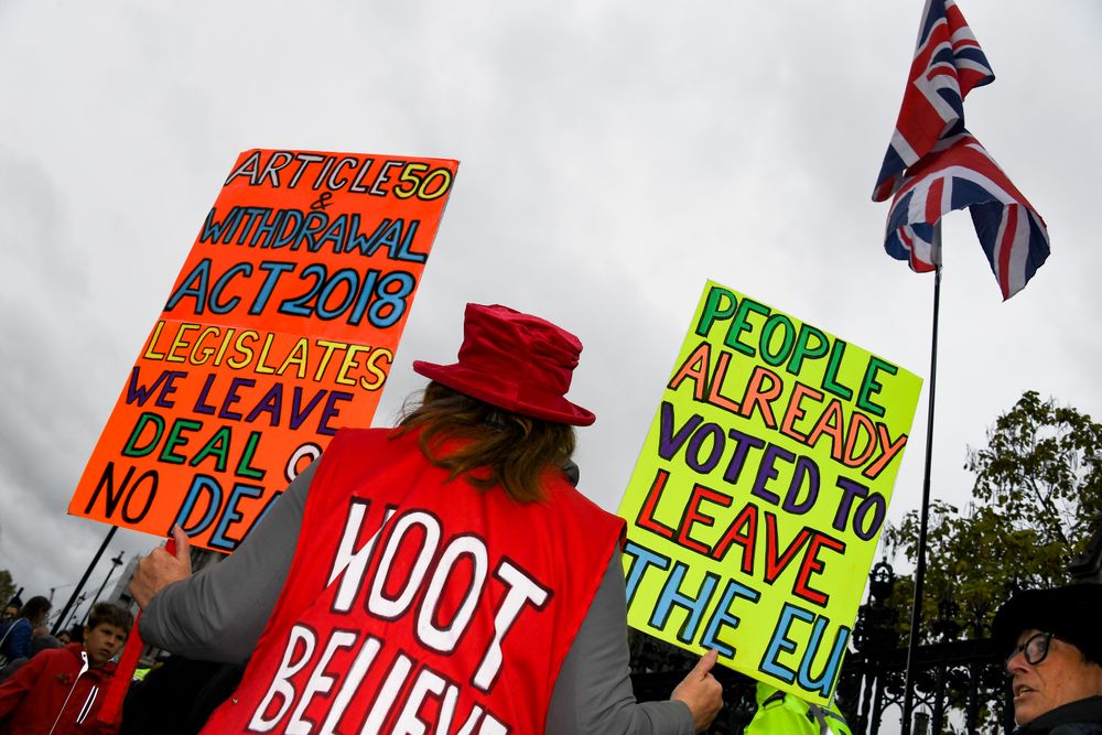 Pro Brexit demonstrators gather outside the Houses of Parliament holding placards and waving Union Flags in London, Monday, Oct. 21, 2019. The European Commission says the fact that British Prime Minister Boris Johnson did not sign a letter requesting a three-month extension of the Brexit deadline has no impact on whether it is valid and that the European Union is considering the request. (AP Photo/Alberto Pezzali) Pro Brexit demonstrators gather outside the Houses of Parliament holding placards and waving Union Flags in London, Monday, Oct. 21, 2019. The European Commission says the fact that British Prime Minister Boris Johnson did not sign a letter requesting a three-month extension of the Brexit deadline has no impact on whether it is valid and that the European Union is considering the request. (AP Photo/Alberto Pezzali)