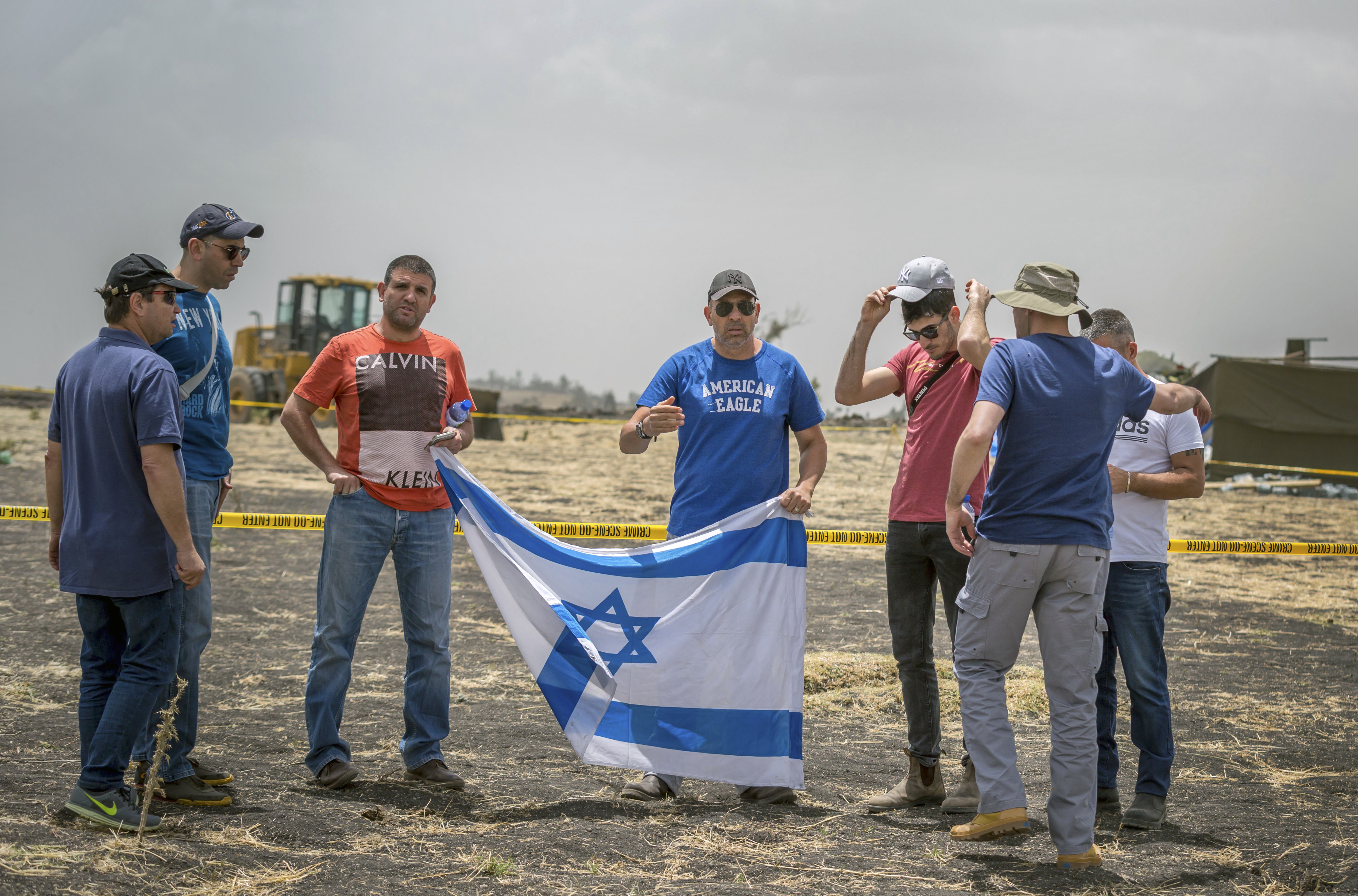Israeli relatives hold their national flag at the scene where the Ethiopian Airlines Boeing 737 Max 8 crashed shortly after takeoff on Sunday killing all 157 on board, near Bishoftu, south-east of Addis Ababa, in Ethiopia Thursday, March 14, 2019. Flight recorders from the doomed Ethiopian Airlines flight arrived in France for analysis Thursday as frustrated relatives of the 157 people killed stormed out of a meeting with airline officials in Addis Ababa. (AP Photo/Mulugeta Ayene) Israeli relatives hold their national flag at the scene where the Ethiopian Airlines Boeing 737 Max 8 crashed shortly after takeoff on Sunday killing all 157 on board, near Bishoftu, south-east of Addis Ababa, in Ethiopia Thursday, March 14, 2019. Flight recorders from the doomed Ethiopian Airlines flight arrived in France for analysis Thursday as frustrated relatives of the 157 people killed stormed out of a meeting with airline officials in Addis Ababa. (AP Photo/Mulugeta Ayene)