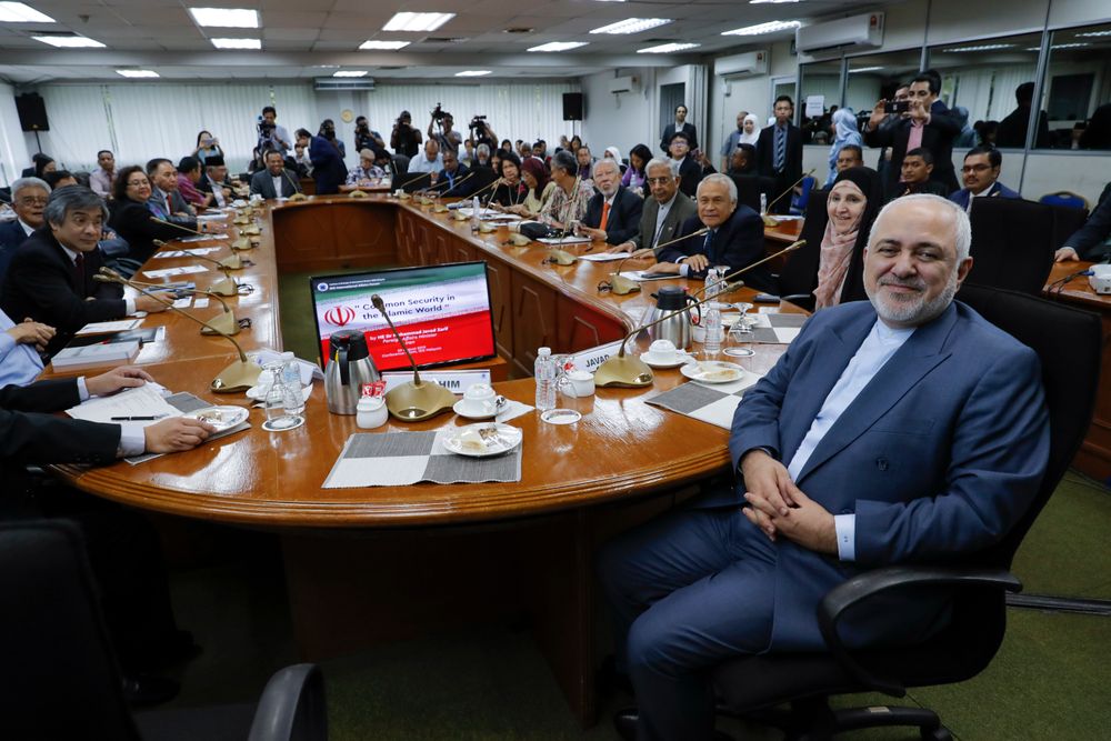 Iranian Foreign Minister Mohammad Javad Zarif, right, smile as he arrives for a forum titled Iranian Foreign Minister Mohammad Javad Zarif, right, smile as he arrives for a forum titled