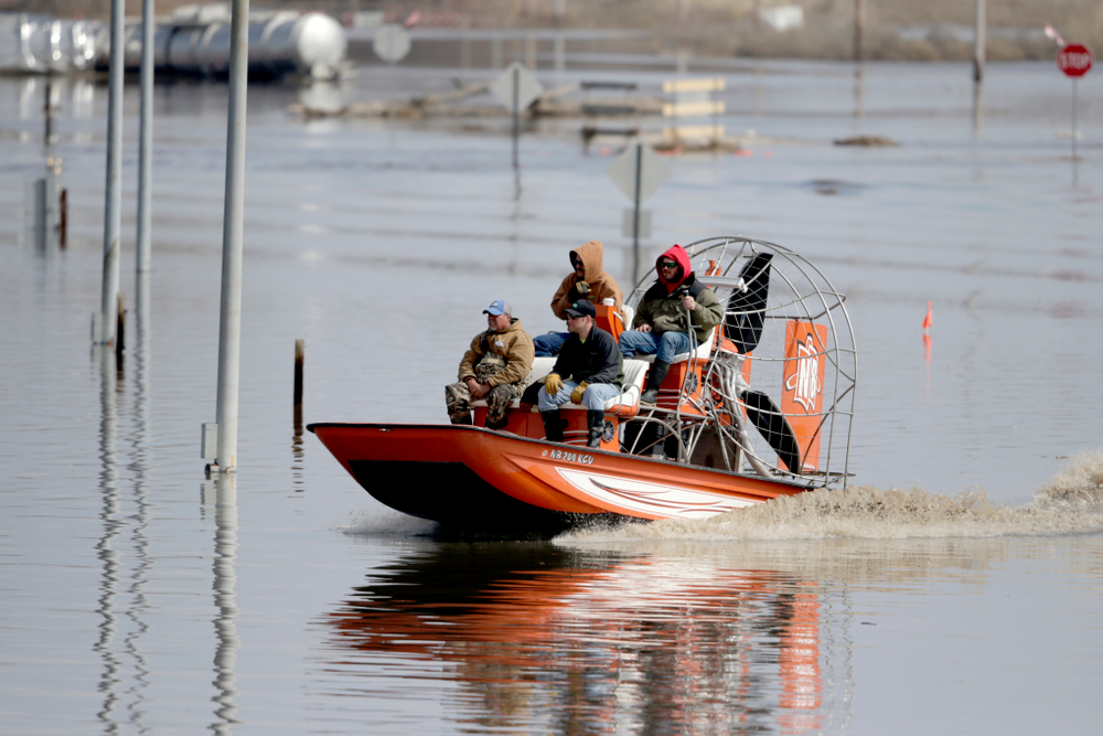 Gabe Schmidt, owner of Liquid Trucking, back right, travels by air boat with Glenn Wyles, top left, Mitch Snyder, bottom right, and Juan Jacobo, bottom left, as they survey damage from the flood waters of the Platte River, in Plattsmouth, Neb., Sunday, March 17, 2019. Hundreds of people remained out of their homes in Nebraska, but rivers there were starting to recede. The National Weather Service said the Elkhorn River remained at major flood stage but was dropping. (AP Photo/Nati Harnik) Gabe Schmidt, owner of Liquid Trucking, back right, travels by air boat with Glenn Wyles, top left, Mitch Snyder, bottom right, and Juan Jacobo, bottom left, as they survey damage from the flood waters of the Platte River, in Plattsmouth, Neb., Sunday, March 17, 2019. Hundreds of people remained out of their homes in Nebraska, but rivers there were starting to recede. The National Weather Service said the Elkhorn River remained at major flood stage but was dropping. (AP Photo/Nati Harnik)