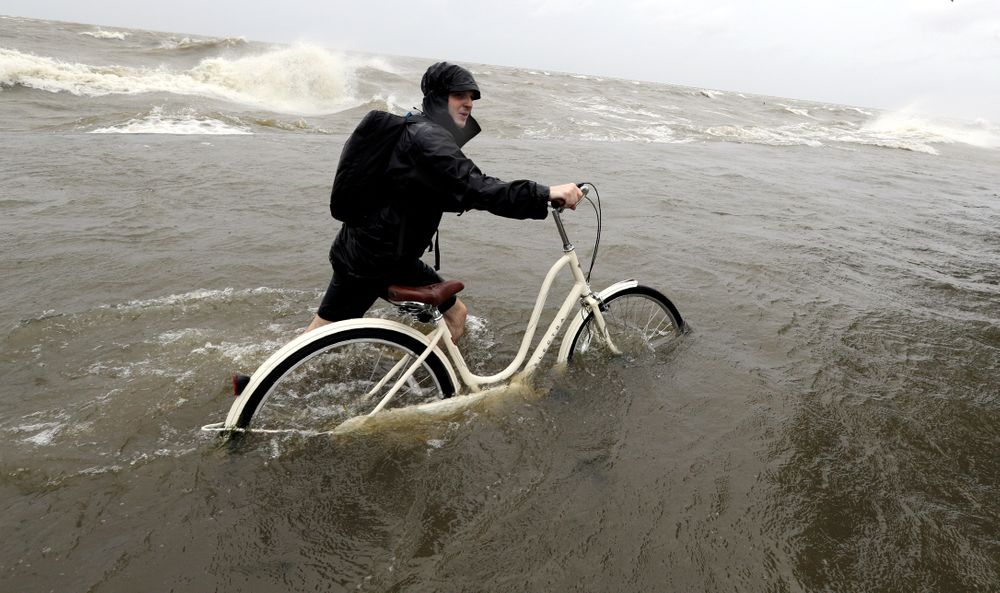 Tyler Holland guides his bike through the water as winds from Tropical Storm Barry push water from Lake Pontchartrain over the seawall Saturday, July 13, 2019, in Mandeville, La. (AP Photo/David J. Phillip) Tyler Holland guides his bike through the water as winds from Tropical Storm Barry push water from Lake Pontchartrain over the seawall Saturday, July 13, 2019, in Mandeville, La. (AP Photo/David J. Phillip)