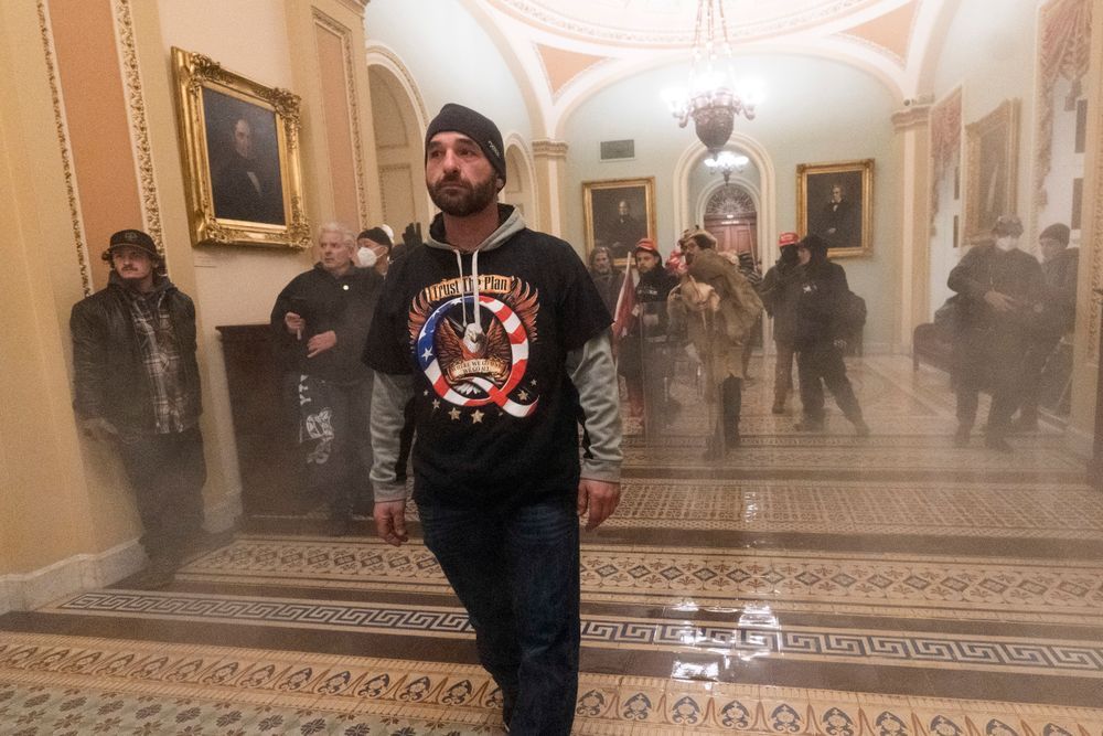 In this Jan. 6, 2021, file photo, smoke fills the walkway outside the Senate Chamber as supporters of President Donald Trump are confronted by U.S. Capitol Police officers inside the Capitol in Washington.
