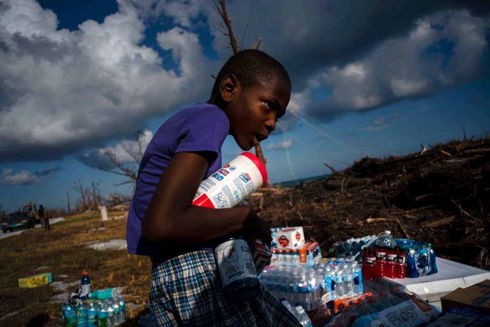 Ayfon Minus, 8, collects donated food that was brought by helicopter from Freeport to the Hurricane Dorian destroyed village of High Rock, Grand Bahama, Bahamas, Tuesday, September 10, 2019. (AP Photo/Ramon Espinosa) Ayfon Minus, 8, collects donated food that was brought by helicopter from Freeport to the Hurricane Dorian destroyed village of High Rock, Grand Bahama, Bahamas, Tuesday, September 10, 2019. (AP Photo/Ramon Espinosa)