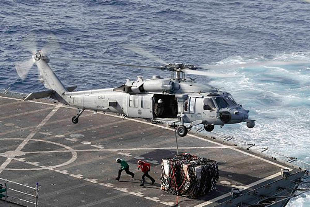 In this Sunday, May 19, 2019 photo, an MH-60S Sea Hawk helicopter transports cargo from the fast combat support ship USNS Arctic to the Nimitz-class aircraft carrier USS Abraham Lincoln during a replenishment-at-sea operation in the Arabian Sea, as Mideast tensions remain high between Tehran and the United States. (Mass Communication Specialist 3rd Class Darion Chanelle Triplett/U.S. Navy via AP) In this Sunday, May 19, 2019 photo, an MH-60S Sea Hawk helicopter transports cargo from the fast combat support ship USNS Arctic to the Nimitz-class aircraft carrier USS Abraham Lincoln during a replenishment-at-sea operation in the Arabian Sea, as Mideast tensions remain high between Tehran and the United States. (Mass Communication Specialist 3rd Class Darion Chanelle Triplett/U.S. Navy via AP)