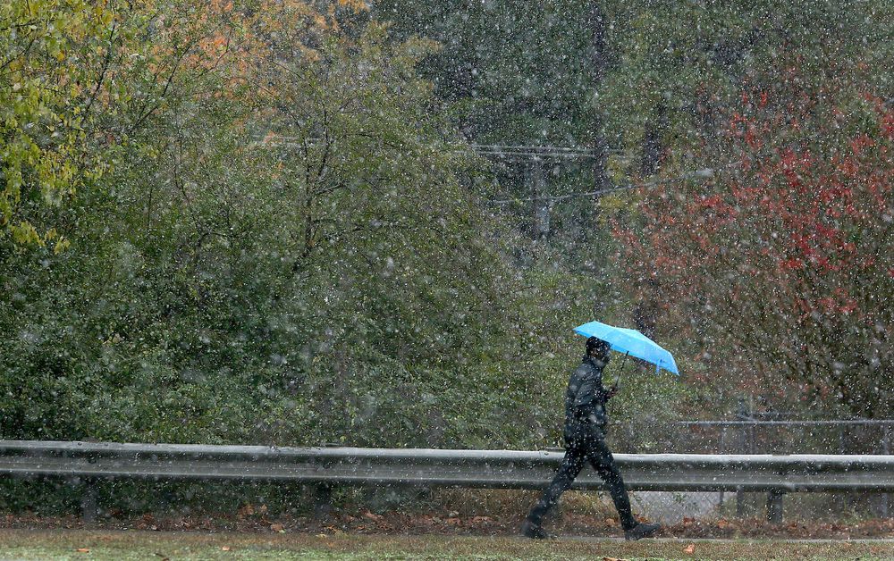 A pedestrian braves the weather as a light snow falls, Tuesday, Nov. 12, 2019 in Newport News, Va. (Rob Ostermaier/The Virginian-Pilot via AP) A pedestrian braves the weather as a light snow falls, Tuesday, Nov. 12, 2019 in Newport News, Va. (Rob Ostermaier/The Virginian-Pilot via AP)