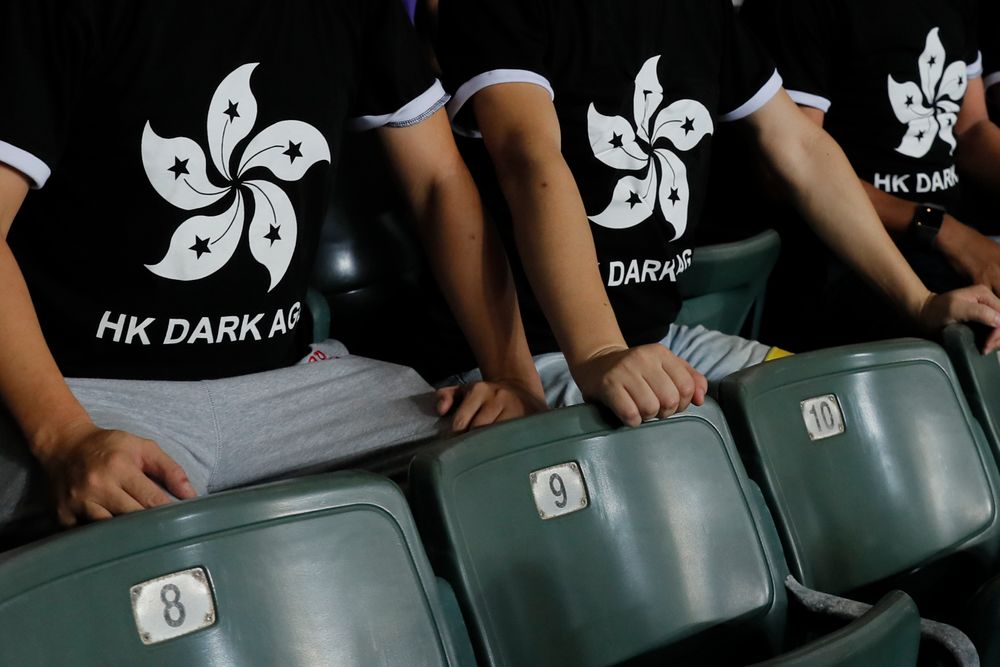 Hong Kong soccer fans wear T-shirt featuring black version of the Hong Kong flags to protest against government during the FIFA World Cup Qatar 2022 and AFC Asian Cup 2023 Preliminary Joint Qualification Round 2 soccer match between Hong Kong and Iran, in Hong Kong, Tuesday, Sept. 10, 2019. The crowd broke out into Hong Kong soccer fans wear T-shirt featuring black version of the Hong Kong flags to protest against government during the FIFA World Cup Qatar 2022 and AFC Asian Cup 2023 Preliminary Joint Qualification Round 2 soccer match between Hong Kong and Iran, in Hong Kong, Tuesday, Sept. 10, 2019. The crowd broke out into