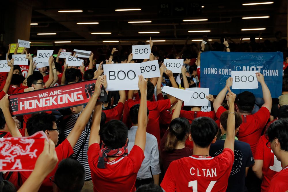 Hong Kong soccer fans turn their back and boo the Chinese national anthem as they chant Hong Kong soccer fans turn their back and boo the Chinese national anthem as they chant