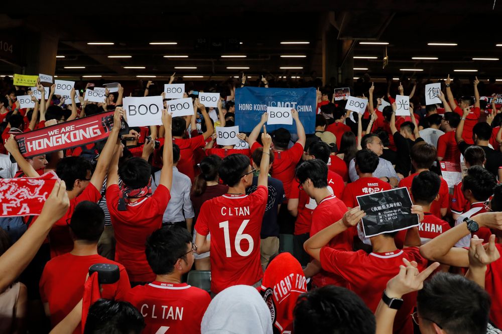 Hong Kong soccer fans turn their back and boo the Chinese national anthem as they chant Hong Kong soccer fans turn their back and boo the Chinese national anthem as they chant