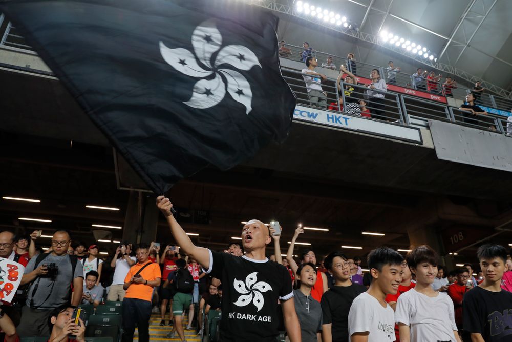Hong Kong soccer fans waves a black version of the Hong Kong flag to protest against government during the FIFA World Cup Qatar 2022 and AFC Asian Cup 2023 Preliminary Joint Qualification Round 2 soccer match between Hong Kong and Iran, in Hong Kong, Tuesday, Sept. 10, 2019. The crowd broke out into Hong Kong soccer fans waves a black version of the Hong Kong flag to protest against government during the FIFA World Cup Qatar 2022 and AFC Asian Cup 2023 Preliminary Joint Qualification Round 2 soccer match between Hong Kong and Iran, in Hong Kong, Tuesday, Sept. 10, 2019. The crowd broke out into