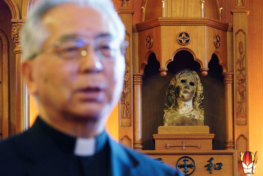 In this Nov. 16, 2019, photo, Japanese Archbishop Mitsuaki Takami, who heads Nagasaki's Catholic community of 60,000, speaks in front of a statue of the Virgin Mary that was damaged in the A-bomb attack at the Urakami Cathedral in Nagasaki, southern Japan. Pope Francis will start his first official visit to Japan in Nagasaki, ground zero for the Christian experience in a nation where the Catholic leader once dreamed of living as a missionary. (AP Photo/Eugene Hoshiko) In this Nov. 16, 2019, photo, Japanese Archbishop Mitsuaki Takami, who heads Nagasaki's Catholic community of 60,000, speaks in front of a statue of the Virgin Mary that was damaged in the A-bomb attack at the Urakami Cathedral in Nagasaki, southern Japan. Pope Francis will start his first official visit to Japan in Nagasaki, ground zero for the Christian experience in a nation where the Catholic leader once dreamed of living as a missionary. (AP Photo/Eugene Hoshiko)