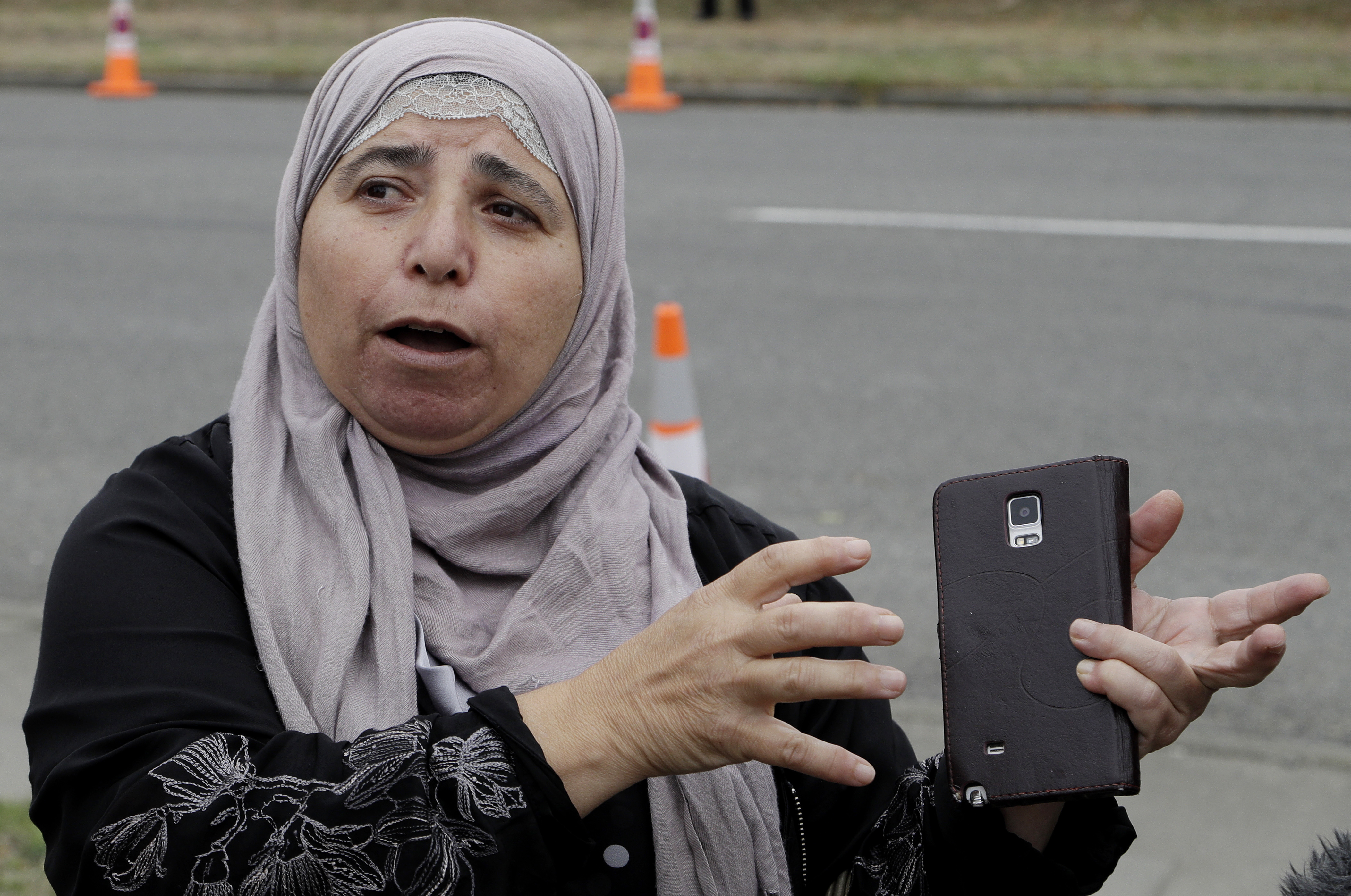 FILE - In this March 18, 2019, file photo, Al Noor mosque shooting survivor Kawthar Abulaban gestures as she explains escaping from the mosque to media in Christchurch, New Zealand. Abulaban was in the women’s prayer area with other women. She heard a single shot at first, enough for some of them to jump up and say, “What’s wrong?” Then there was a pause and a second shot and a dawning realization. Soon, there was a barrage of bullets. (AP Photo/Mark Baker, File) FILE - In this March 18, 2019, file photo, Al Noor mosque shooting survivor Kawthar Abulaban gestures as she explains escaping from the mosque to media in Christchurch, New Zealand. Abulaban was in the women’s prayer area with other women. She heard a single shot at first, enough for some of them to jump up and say, “What’s wrong?” Then there was a pause and a second shot and a dawning realization. Soon, there was a barrage of bullets. (AP Photo/Mark Baker, File)