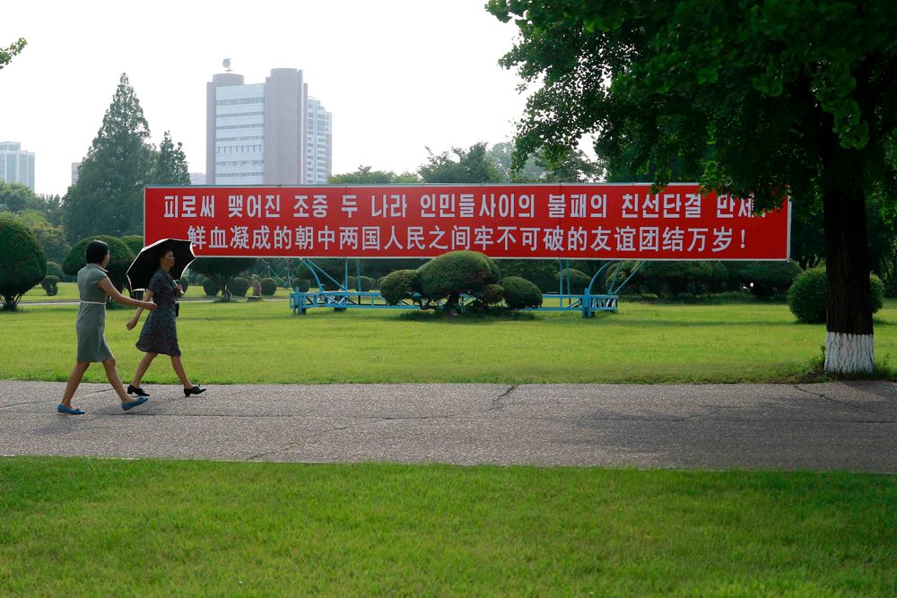 Women walk by a sign that reads: Women walk by a sign that reads:
