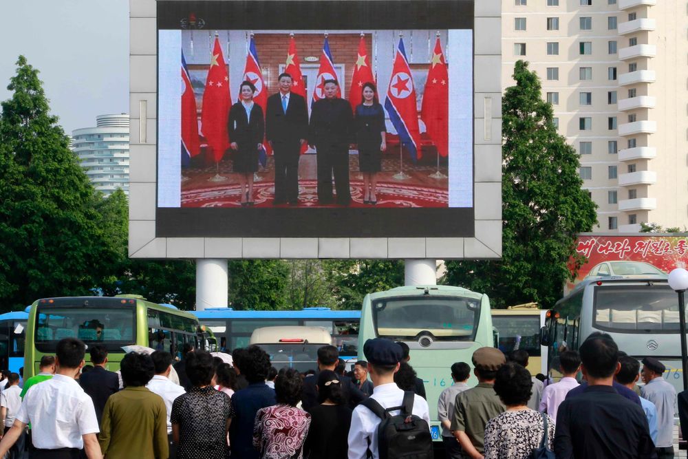 People watch a large screen showing an image of Chinese President Xi Jinping, second from left, posing with his wife Peng Liyuan, left, North Korean leader Kim Jong Un and his wife Ri Sol Ju, at Pyongyang Railway Station in Pyongyang, North Korea, Friday, June 21, 2019. Xi offered encouragement for North Korea’s focus on economic development in a speech in Pyongyang, turning to a topic Beijing has long pressed with its communist neighbor amid wider concerns over the North’s nuclear weapons program. (AP Photo/Jon Chol Jin) People watch a large screen showing an image of Chinese President Xi Jinping, second from left, posing with his wife Peng Liyuan, left, North Korean leader Kim Jong Un and his wife Ri Sol Ju, at Pyongyang Railway Station in Pyongyang, North Korea, Friday, June 21, 2019. Xi offered encouragement for North Korea’s focus on economic development in a speech in Pyongyang, turning to a topic Beijing has long pressed with its communist neighbor amid wider concerns over the North’s nuclear weapons program. (AP Photo/Jon Chol Jin)
