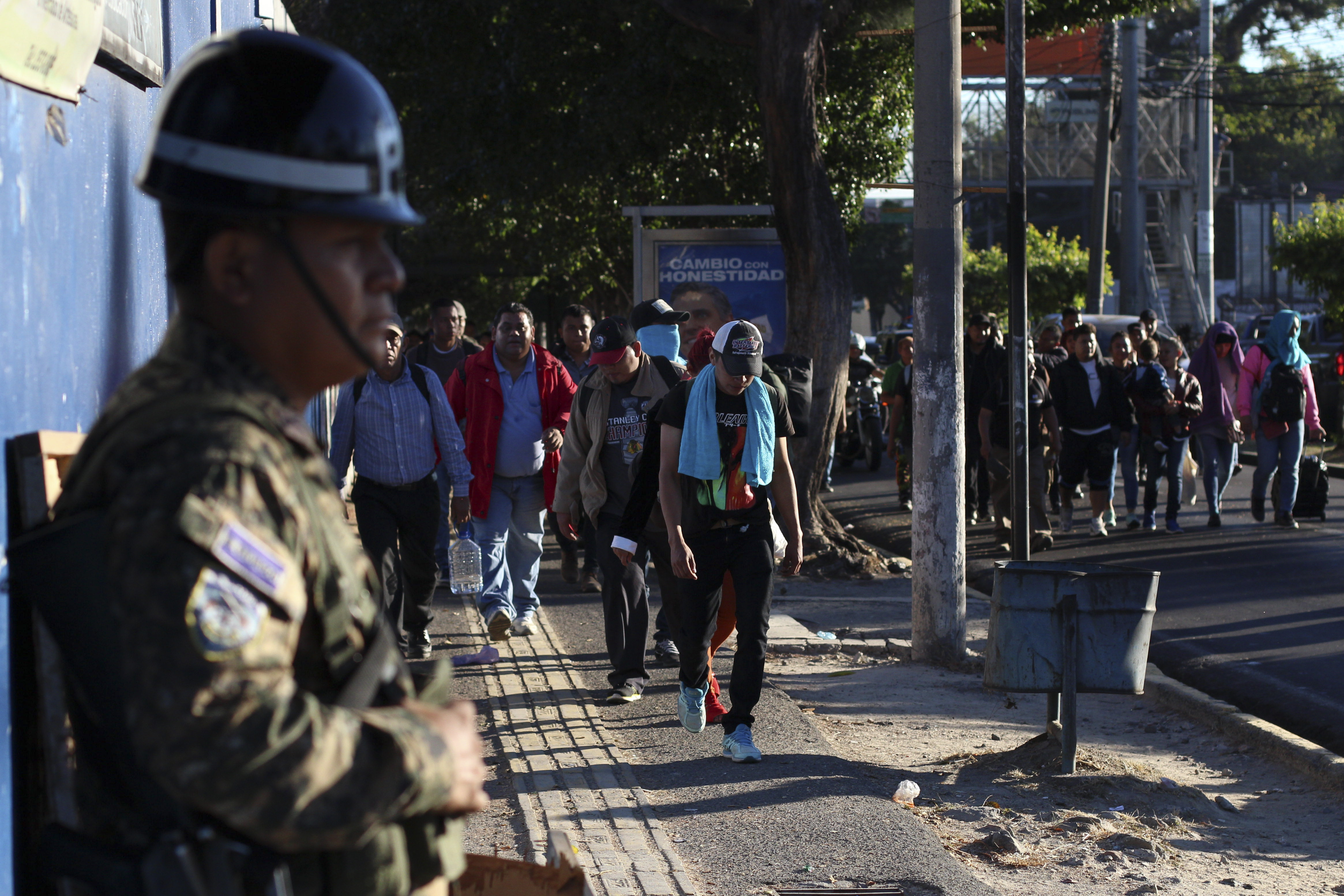 Police stand by as locals begin their journey north toward the U.S. border, during a migrant caravan passing through the capital of San Salvador, El Salvador, early Wednesday, Jan. 16, 2019. Migrants fleeing Central America's Northern Triangle region comprising Honduras, El Salvador and Guatemala routinely cite poverty and rampant gang violence as their motivation for leaving. (AP Photo/Salvador Melendez) Police stand by as locals begin their journey north toward the U.S. border, during a migrant caravan passing through the capital of San Salvador, El Salvador, early Wednesday, Jan. 16, 2019. Migrants fleeing Central America's Northern Triangle region comprising Honduras, El Salvador and Guatemala routinely cite poverty and rampant gang violence as their motivation for leaving. (AP Photo/Salvador Melendez)