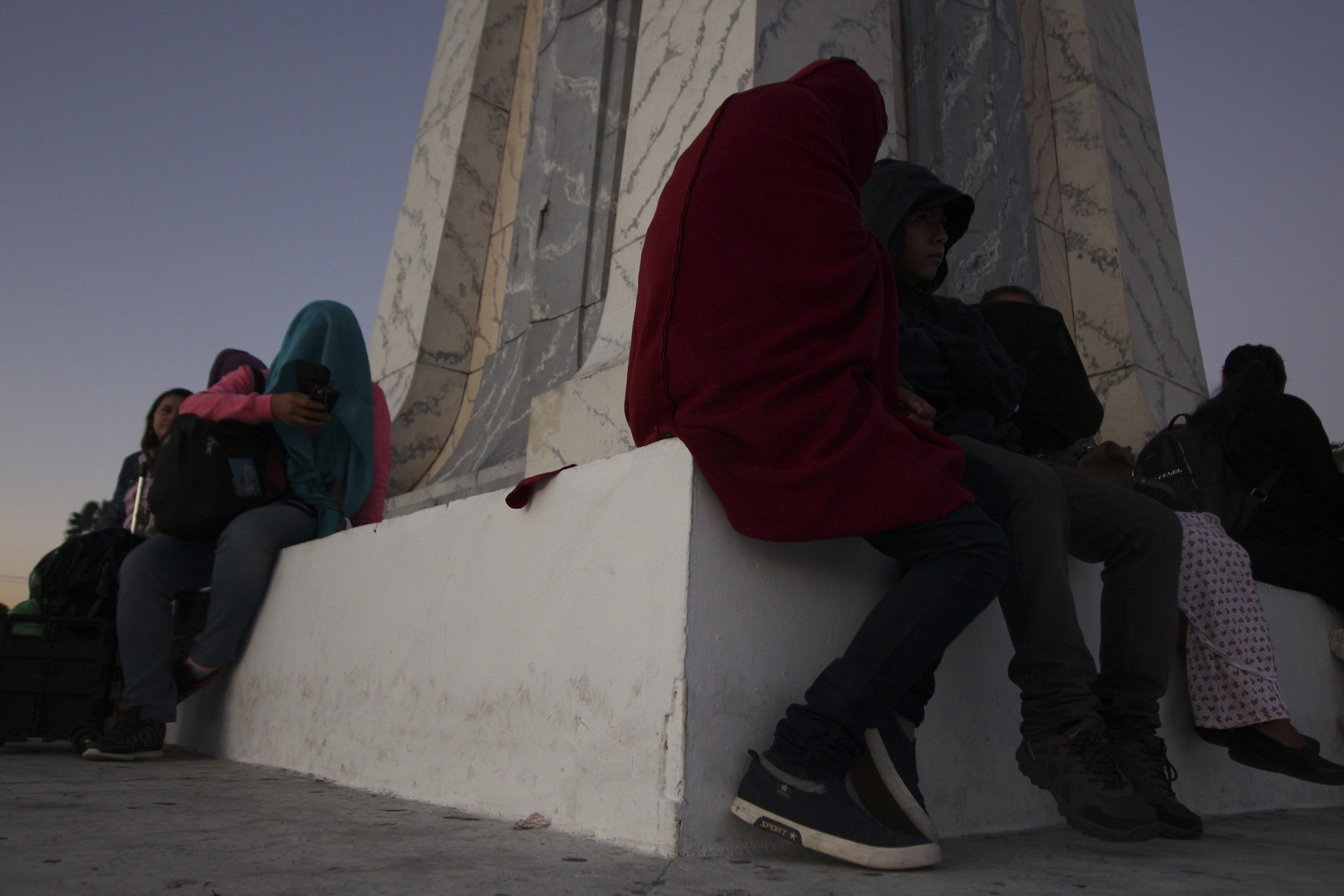 Locals, some with their faces covered to avoid identification and gang threats, prepare to set off toward the U.S. border with a migrant caravan, in San Salvador, El Salvador, at dawn Wednesday, Jan. 16, 2019. Migrants fleeing Central America's Northern Triangle region comprising Honduras, El Salvador and Guatemala routinely cite poverty and rampant gang violence as their motivation for leaving. (AP Photo/Salvador Melendez) Locals, some with their faces covered to avoid identification and gang threats, prepare to set off toward the U.S. border with a migrant caravan, in San Salvador, El Salvador, at dawn Wednesday, Jan. 16, 2019. Migrants fleeing Central America's Northern Triangle region comprising Honduras, El Salvador and Guatemala routinely cite poverty and rampant gang violence as their motivation for leaving. (AP Photo/Salvador Melendez)