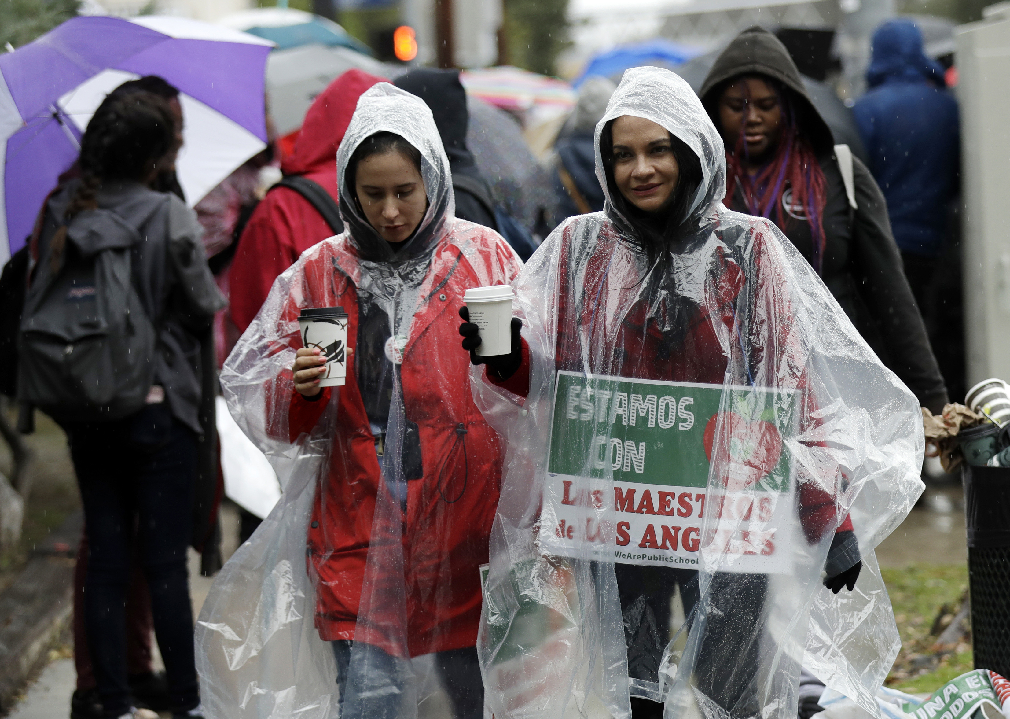 Spanish teachers Natalie Ardagna, right, and Jenny Padilla cover themselves from the rain as they protest outside of North Hollywood High School Tuesday, Jan. 15, 2019, in Los Angeles. Teachers in the huge Los Angeles Unified School District walked picket lines again Tuesday as administrators urged them to return to classrooms and for their union to return to the bargaining table. (AP Photo/Marcio Jose Sanchez) Spanish teachers Natalie Ardagna, right, and Jenny Padilla cover themselves from the rain as they protest outside of North Hollywood High School Tuesday, Jan. 15, 2019, in Los Angeles. Teachers in the huge Los Angeles Unified School District walked picket lines again Tuesday as administrators urged them to return to classrooms and for their union to return to the bargaining table. (AP Photo/Marcio Jose Sanchez)