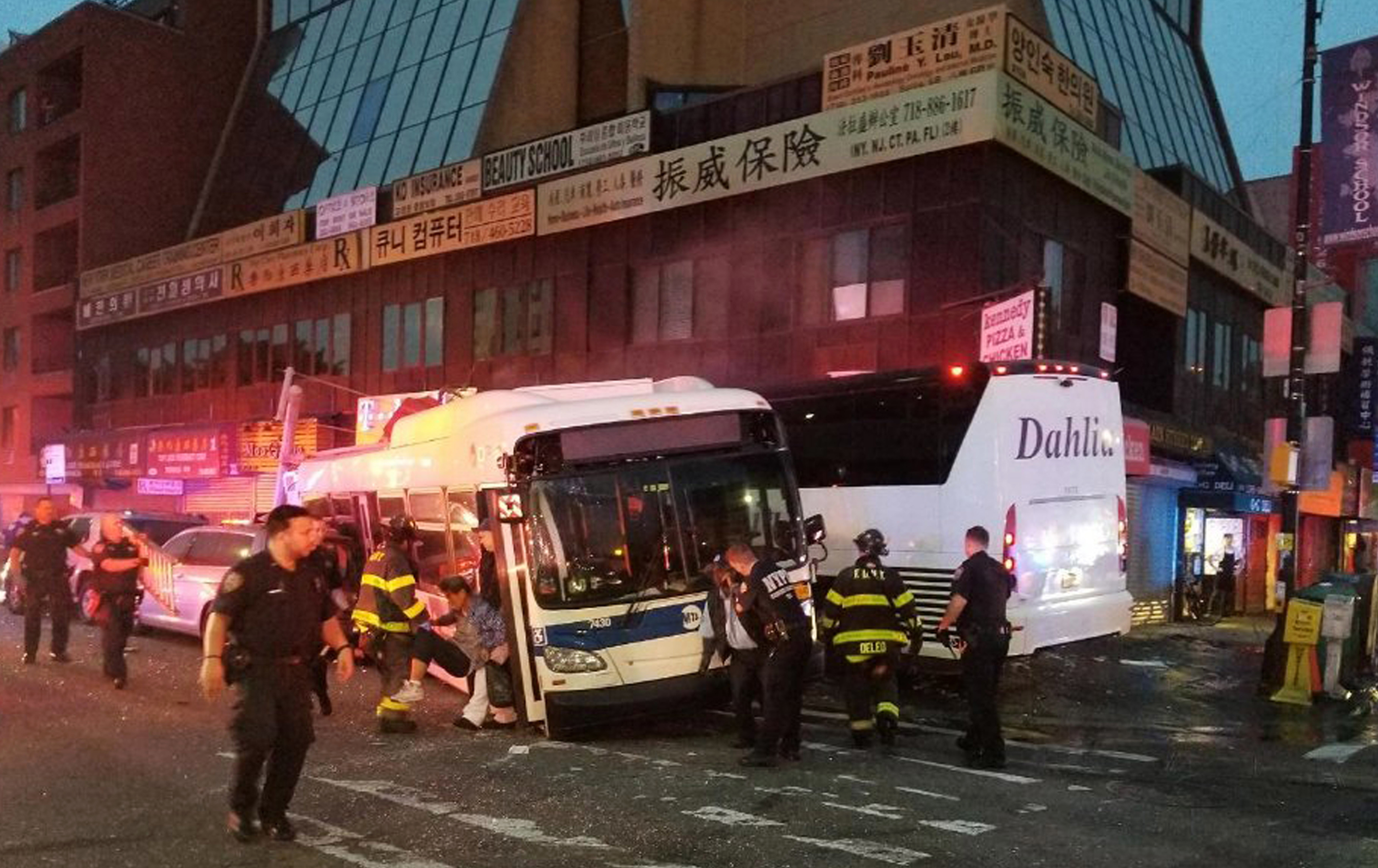 FILE - In this Monday, Sept. 18, 2017 photo provided by the NYPD's 109th Precinct, officers respond to a collision involving two buses on Main Street in the Queens borough of New York. Federal safety investigators say a freak accident involving a dropped thermos may have caused a bus crash that killed three people in New York City. The National Transportation Safety Board released its report Thursday, Feb. 21, 2019. The incident occurred when a charter bus blew threw a Queens intersection at 60 mph, slammed into a city bus, barreled across a sidewalk and hit a building. The charter bus driver, a city bus passenger and a pedestrian were killed. (NYPD's 109th Precinct via AP, File) FILE - In this Monday, Sept. 18, 2017 photo provided by the NYPD's 109th Precinct, officers respond to a collision involving two buses on Main Street in the Queens borough of New York. Federal safety investigators say a freak accident involving a dropped thermos may have caused a bus crash that killed three people in New York City. The National Transportation Safety Board released its report Thursday, Feb. 21, 2019. The incident occurred when a charter bus blew threw a Queens intersection at 60 mph, slammed into a city bus, barreled across a sidewalk and hit a building. The charter bus driver, a city bus passenger and a pedestrian were killed. (NYPD's 109th Precinct via AP, File)