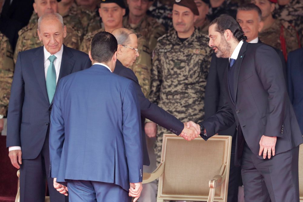 Lebanese President Michel Aoun, center, shakes hands with former Prime Minister Saad Hariri, right, and Parliament Speaker Nabih Berri, before a military parade to mark the 76th anniversary of Lebanon's independence from France at the Lebanese Defense Ministry, in Yarzeh near Beirut, Lebanon, Friday, Nov. 22, 2019. Lebanon's top politicians attended Friday a military parade on the country's 76th Independence Day, appearing for the first time since the government resigned amid nationwide protests now in their second month. (AP Photo/Hassan Ammar) Lebanese President Michel Aoun, center, shakes hands with former Prime Minister Saad Hariri, right, and Parliament Speaker Nabih Berri, before a military parade to mark the 76th anniversary of Lebanon's independence from France at the Lebanese Defense Ministry, in Yarzeh near Beirut, Lebanon, Friday, Nov. 22, 2019. Lebanon's top politicians attended Friday a military parade on the country's 76th Independence Day, appearing for the first time since the government resigned amid nationwide protests now in their second month. (AP Photo/Hassan Ammar)