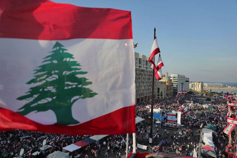 Anti-government protesters gather during separate civil parade at the Martyr square, in downtown Beirut, Lebanon, Friday, Nov. 22, 2019. Protesters gathered for their own alternative independence celebrations, converging by early afternoon on Martyrs' square in central Beirut, which used to be the traditional location for the official parade. Protesters have occupied the area, closing it off to traffic since mid-October. (AP Photo/Hassan Ammar) Anti-government protesters gather during separate civil parade at the Martyr square, in downtown Beirut, Lebanon, Friday, Nov. 22, 2019. Protesters gathered for their own alternative independence celebrations, converging by early afternoon on Martyrs' square in central Beirut, which used to be the traditional location for the official parade. Protesters have occupied the area, closing it off to traffic since mid-October. (AP Photo/Hassan Ammar)