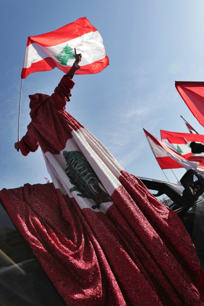 An anti-government protester wears a robe presenting the Lebanese national flag during an alternative independence celebrations at the Martyr square, in downtown Beirut, Lebanon, Friday, Nov. 22, 2019. Protesters gathered for their own alternative independence celebrations, converging by early afternoon on Martyrs' square in central Beirut, which used to be the traditional location for the official parade. Protesters have occupied the area, closing it off to traffic since mid-October. (AP Photo/Hassan Ammar) An anti-government protester wears a robe presenting the Lebanese national flag during an alternative independence celebrations at the Martyr square, in downtown Beirut, Lebanon, Friday, Nov. 22, 2019. Protesters gathered for their own alternative independence celebrations, converging by early afternoon on Martyrs' square in central Beirut, which used to be the traditional location for the official parade. Protesters have occupied the area, closing it off to traffic since mid-October. (AP Photo/Hassan Ammar)