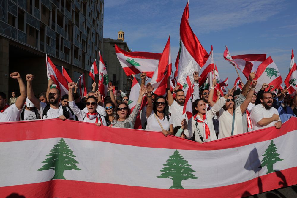 Anti-government protesters shout slogans during separate civil parade at the Martyr square, in downtown Beirut, Lebanon, Friday, Nov. 22, 2019. Protesters gathered for alternative independence celebrations, converging by early afternoon on Martyrs’ Square in central Beirut, which used to be the traditional location of the official parade. Protesters have occupied the area, closing it off to traffic since mid-October. (AP Photo/Hassan Ammar) Anti-government protesters shout slogans during separate civil parade at the Martyr square, in downtown Beirut, Lebanon, Friday, Nov. 22, 2019. Protesters gathered for alternative independence celebrations, converging by early afternoon on Martyrs’ Square in central Beirut, which used to be the traditional location of the official parade. Protesters have occupied the area, closing it off to traffic since mid-October. (AP Photo/Hassan Ammar)