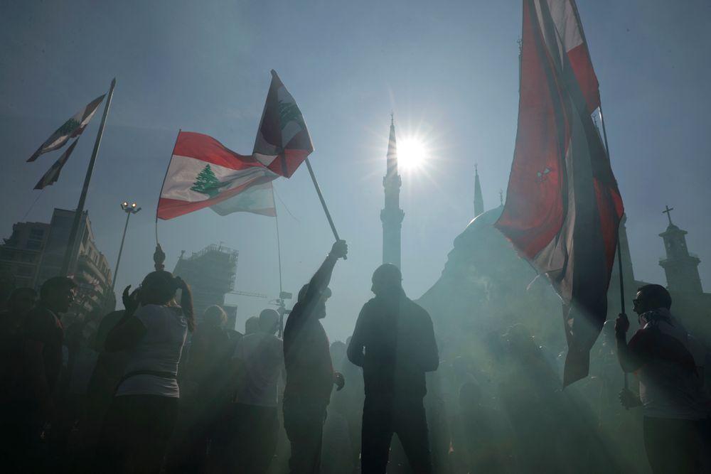 Anti-government protesters wave Lebanese national flags as gather during separate civil parade at the Martyr square, in downtown Beirut, Lebanon, Friday, Nov. 22, 2019. Protesters gathered for alternative independence celebrations, converging by early afternoon on Martyrs’ Square in central Beirut, which used to be the traditional location of the official parade. Protesters have occupied the area, closing it off to traffic since mid-October. (AP Photo/Hassan Ammar) Anti-government protesters wave Lebanese national flags as gather during separate civil parade at the Martyr square, in downtown Beirut, Lebanon, Friday, Nov. 22, 2019. Protesters gathered for alternative independence celebrations, converging by early afternoon on Martyrs’ Square in central Beirut, which used to be the traditional location of the official parade. Protesters have occupied the area, closing it off to traffic since mid-October. (AP Photo/Hassan Ammar)