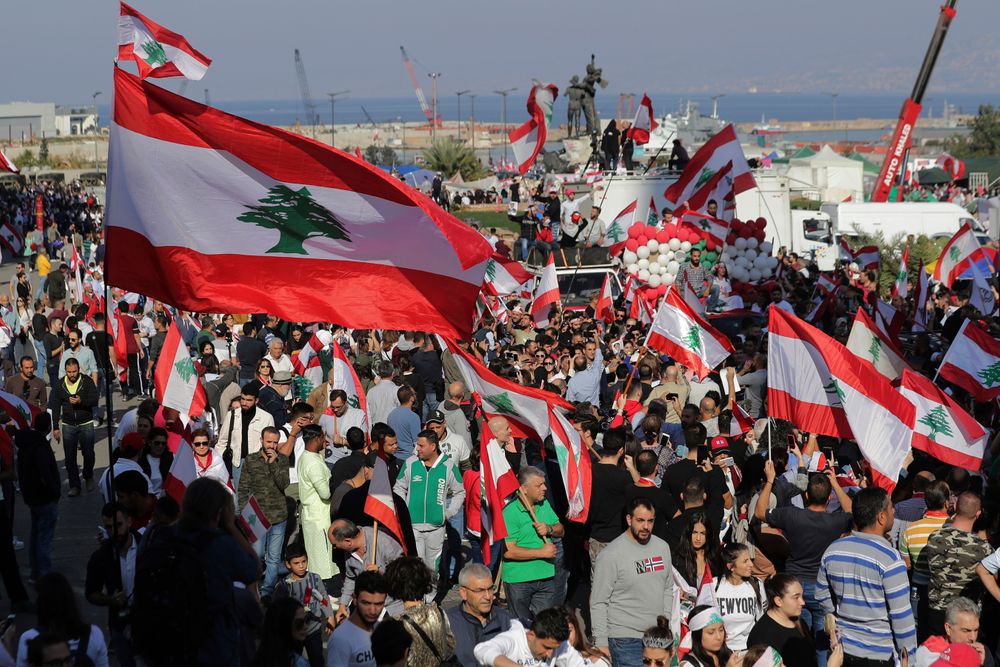 Anti-government protesters gather during separate civil parade at the Martyr square, in downtown Beirut, Lebanon, Friday, Nov. 22, 2019. Protesters gathered for their own alternative independence celebrations, converging by early afternoon on Martyrs' square in central Beirut, which used to be the traditional location for the official parade. Protesters have occupied the area, closing it off to traffic since mid-October. (AP Photo/Hassan Ammar) Anti-government protesters gather during separate civil parade at the Martyr square, in downtown Beirut, Lebanon, Friday, Nov. 22, 2019. Protesters gathered for their own alternative independence celebrations, converging by early afternoon on Martyrs' square in central Beirut, which used to be the traditional location for the official parade. Protesters have occupied the area, closing it off to traffic since mid-October. (AP Photo/Hassan Ammar)