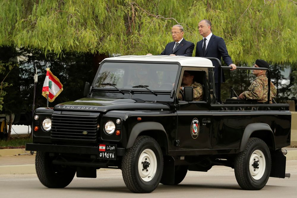 Lebanese President Michel Aoun, left, and Defense Minister Elias Bou Saab, right, stand on a military vehicle before they review Lebanese soldier units during a military parade to mark the 76th anniversary of Lebanon's independence from France at the Lebanese Defense Ministry, in Yarzeh near Beirut, Lebanon, Friday, Nov. 22, 2019. Lebanon's top politicians attended Friday a military parade on the country's 76th Independence Day, appearing for the first time since the government resigned amid nationwide protests now in their second month. (AP Photo/Hassan Ammar) Lebanese President Michel Aoun, left, and Defense Minister Elias Bou Saab, right, stand on a military vehicle before they review Lebanese soldier units during a military parade to mark the 76th anniversary of Lebanon's independence from France at the Lebanese Defense Ministry, in Yarzeh near Beirut, Lebanon, Friday, Nov. 22, 2019. Lebanon's top politicians attended Friday a military parade on the country's 76th Independence Day, appearing for the first time since the government resigned amid nationwide protests now in their second month. (AP Photo/Hassan Ammar)