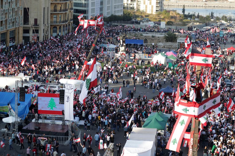 Anti-government protesters gather during separate civil parade at the Martyr square, in downtown Beirut, Lebanon, Friday, Nov. 22, 2019. Protesters gathered for their own alternative independence celebrations, converging by early afternoon on Martyrs' square in central Beirut, which used to be the traditional location for the official parade. Protesters have occupied the area, closing it off to traffic since mid-October. (AP Photo/Hassan Ammar) Anti-government protesters gather during separate civil parade at the Martyr square, in downtown Beirut, Lebanon, Friday, Nov. 22, 2019. Protesters gathered for their own alternative independence celebrations, converging by early afternoon on Martyrs' square in central Beirut, which used to be the traditional location for the official parade. Protesters have occupied the area, closing it off to traffic since mid-October. (AP Photo/Hassan Ammar)