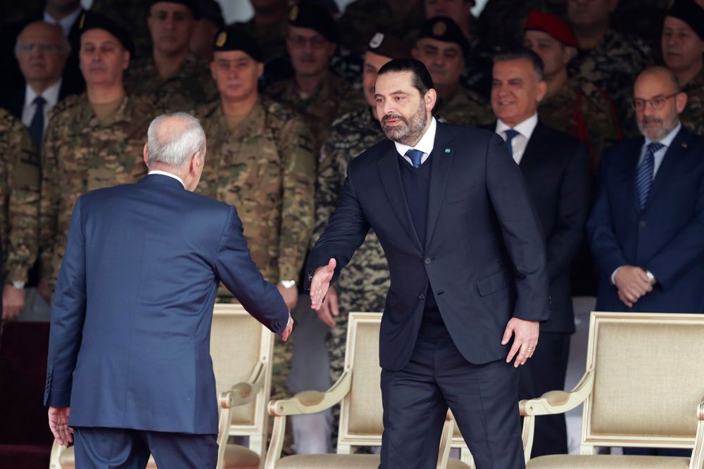 Former Prime Minister Saad Hariri, right, shakes hands with Lebanese Parliament Speaker Nabih Berri as attend a military parade to mark the 76th anniversary of Lebanon's independence from France at the Lebanese Defense Ministry, in Yarzeh near Beirut, Lebanon, Friday, Nov. 22, 2019. Lebanon's top politicians Friday, attended a military parade on the country's 76th Independence Day, appearing for the first time since the government resigned amid nationwide protests now in their second month. (AP Photo/Hassan Ammar) Former Prime Minister Saad Hariri, right, shakes hands with Lebanese Parliament Speaker Nabih Berri as attend a military parade to mark the 76th anniversary of Lebanon's independence from France at the Lebanese Defense Ministry, in Yarzeh near Beirut, Lebanon, Friday, Nov. 22, 2019. Lebanon's top politicians Friday, attended a military parade on the country's 76th Independence Day, appearing for the first time since the government resigned amid nationwide protests now in their second month. (AP Photo/Hassan Ammar)