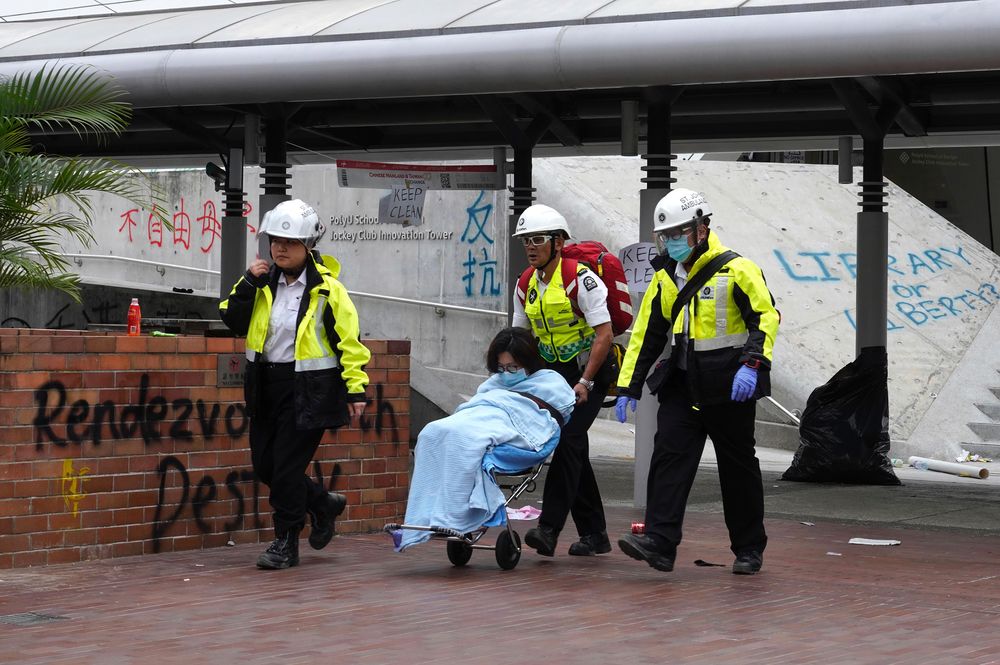 Medical workers escort a protester from Hong Kong Polytechnic University in Hong Kong, Wednesday, Nov. 20, 2019. A small band of anti-government protesters, their numbers diminished by surrenders and failed escape attempts, remained holed up at a Hong Kong university early Wednesday as they braced for the endgame in a police siege of the campus. (AP Photo/Vincent Yu) Medical workers escort a protester from Hong Kong Polytechnic University in Hong Kong, Wednesday, Nov. 20, 2019. A small band of anti-government protesters, their numbers diminished by surrenders and failed escape attempts, remained holed up at a Hong Kong university early Wednesday as they braced for the endgame in a police siege of the campus. (AP Photo/Vincent Yu)