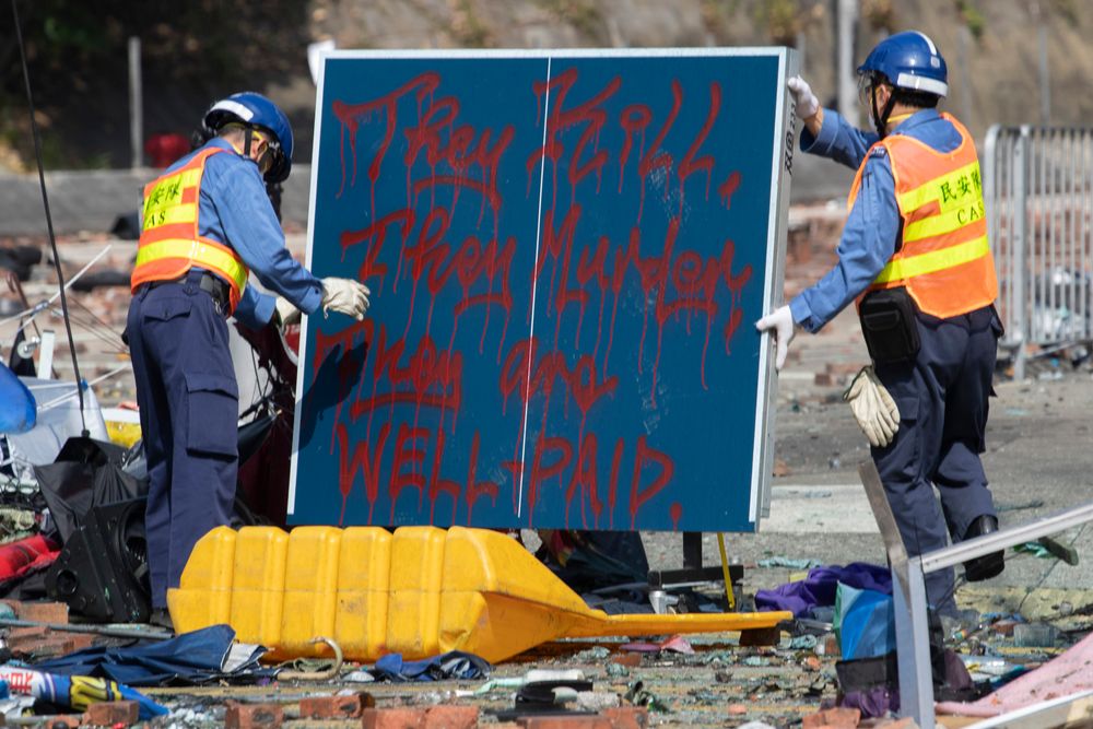 Workers remove a board with the words referring to the police force Workers remove a board with the words referring to the police force