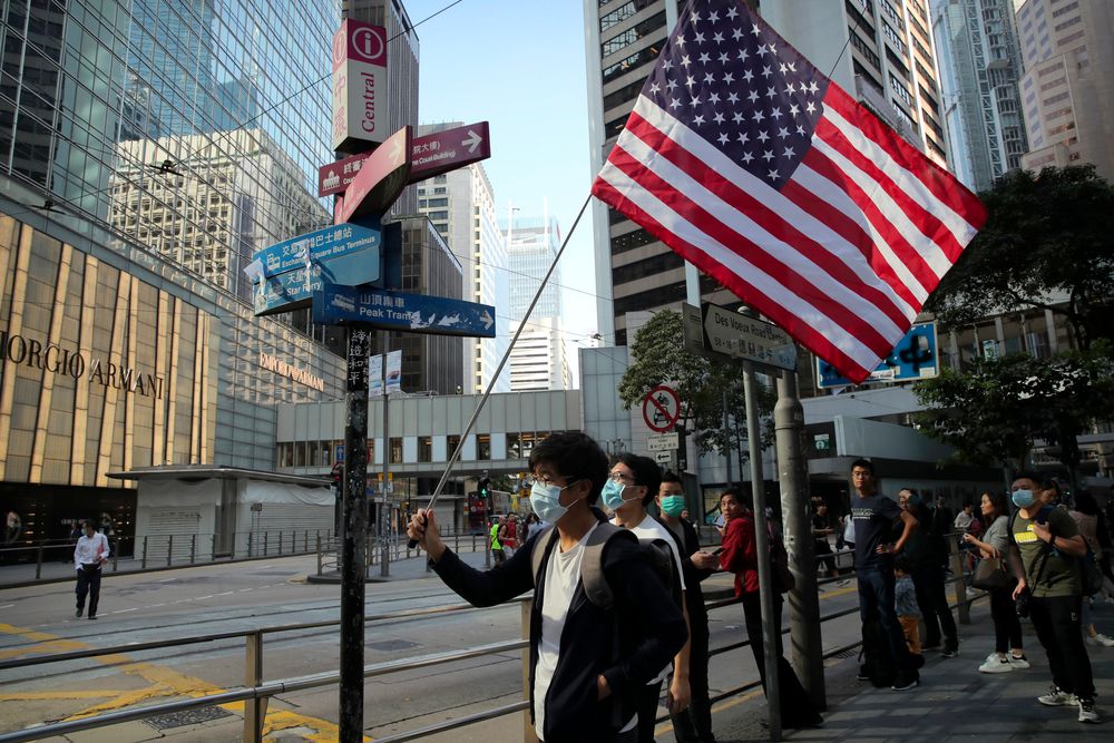 A protester holds an American flag during a demonstration in the financial district in Hong Kong, Wednesday, Nov. 20, 2019. Hong Kong schools reopened Wednesday after a six-day shutdown but students and commuters faced transit disruptions as the last protesters remained holed up on a university campus. (AP Photo/Kin Cheung) A protester holds an American flag during a demonstration in the financial district in Hong Kong, Wednesday, Nov. 20, 2019. Hong Kong schools reopened Wednesday after a six-day shutdown but students and commuters faced transit disruptions as the last protesters remained holed up on a university campus. (AP Photo/Kin Cheung)