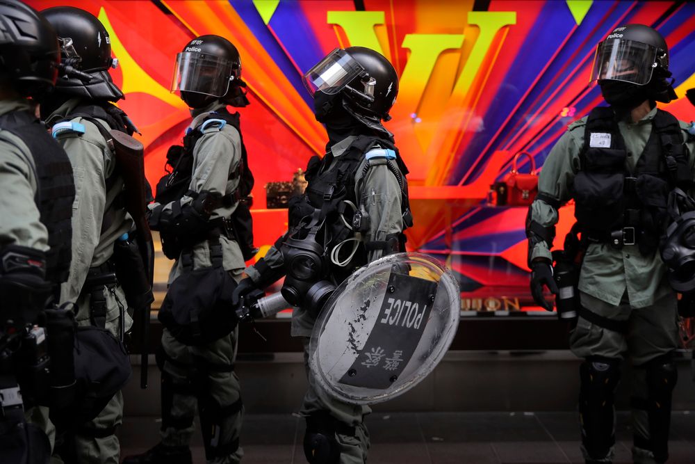 Riot police gather near a Louis Vuitton store during a demonstration in the financial district in Hong Kong, Wednesday, Nov. 20, 2019. Hong Kong schools reopened Wednesday after a six-day shutdown but students and commuters faced transit disruptions as the last protesters remained holed up on a university campus. (AP Photo/Kin Cheung) Riot police gather near a Louis Vuitton store during a demonstration in the financial district in Hong Kong, Wednesday, Nov. 20, 2019. Hong Kong schools reopened Wednesday after a six-day shutdown but students and commuters faced transit disruptions as the last protesters remained holed up on a university campus. (AP Photo/Kin Cheung)