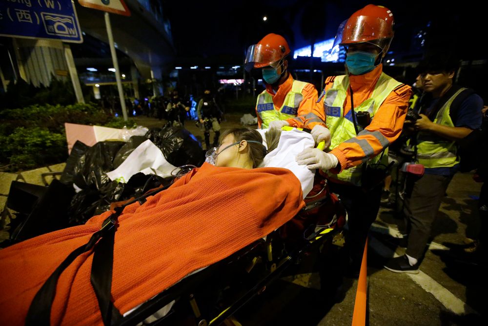 Medical workers transport an injured protester on a stretcher near Hong Kong Polytechnic University in Hong Kong, Tuesday, Nov. 19, 2019. A small band of anti-government protesters, their numbers diminished by surrenders and failed escape attempts, remained holed up at a Hong Kong university early Wednesday as they braced for the endgame in a police siege of the campus. (AP Photo/Achmad Ibrahim) Medical workers transport an injured protester on a stretcher near Hong Kong Polytechnic University in Hong Kong, Tuesday, Nov. 19, 2019. A small band of anti-government protesters, their numbers diminished by surrenders and failed escape attempts, remained holed up at a Hong Kong university early Wednesday as they braced for the endgame in a police siege of the campus. (AP Photo/Achmad Ibrahim)