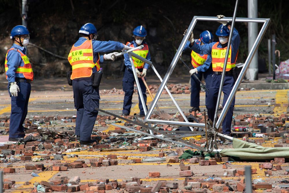 Workers start to clean up the road outside the Hong Kong Polytechnic University in Hong Kong on Wednesday, Nov. 20, 2019. Hong Kong schools have reopened after a six-day shutdown but students were facing transit disruptions as the last protesters remained holed up on a university campus. (AP Photo/Ng Han Guan) Workers start to clean up the road outside the Hong Kong Polytechnic University in Hong Kong on Wednesday, Nov. 20, 2019. Hong Kong schools have reopened after a six-day shutdown but students were facing transit disruptions as the last protesters remained holed up on a university campus. (AP Photo/Ng Han Guan)