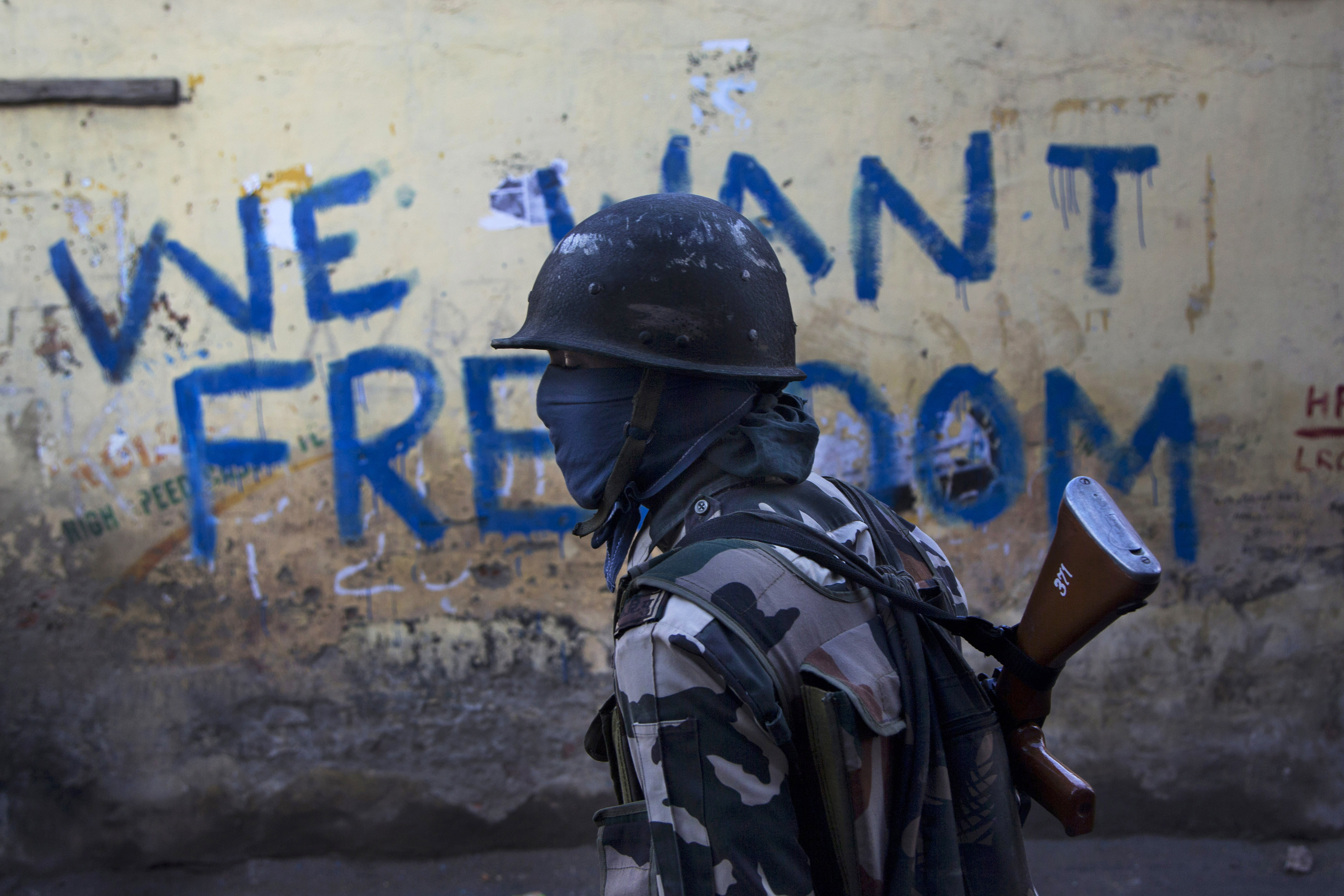 FILE- In this Aug. 29, 2016 file photo, an Indian paramilitary soldier walks past graffiti on a wall in Srinagar, Indian-controlled Kashmir. As India considers its response to the suicide car bombing of a paramilitary convoy in Kashmir that killed dozens of soldiers on Feb. 14, 2019, a retired military commander who oversaw a much-lauded military strike against neighboring Pakistan in 2016 has urged caution. India blamed the attack on Pakistan and promised a FILE- In this Aug. 29, 2016 file photo, an Indian paramilitary soldier walks past graffiti on a wall in Srinagar, Indian-controlled Kashmir. As India considers its response to the suicide car bombing of a paramilitary convoy in Kashmir that killed dozens of soldiers on Feb. 14, 2019, a retired military commander who oversaw a much-lauded military strike against neighboring Pakistan in 2016 has urged caution. India blamed the attack on Pakistan and promised a
