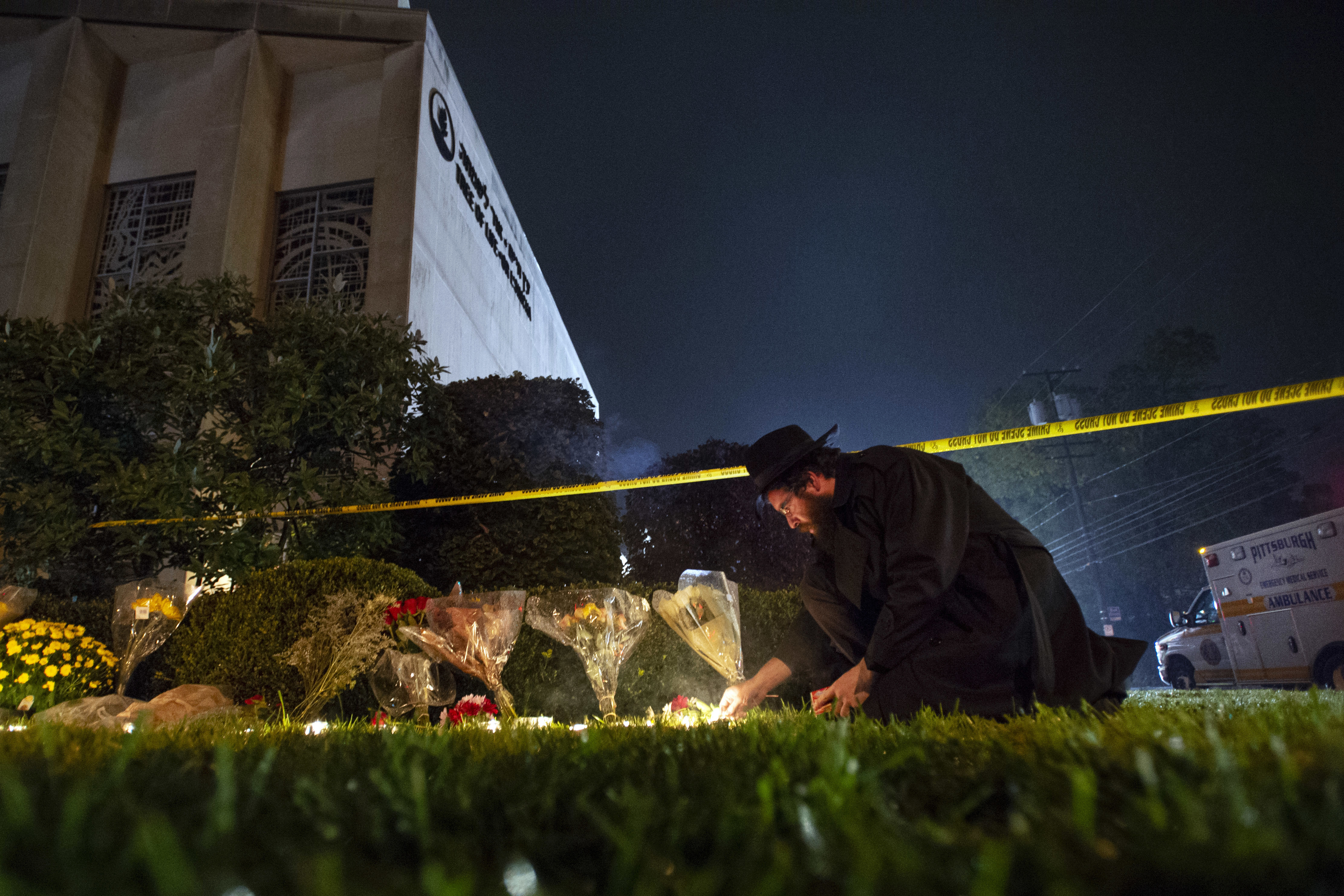 FILE - In this Oct. 27, 2018 photo, Rabbi Eli Wilansky lights a candle after a mass shooting at Tree of Life Synagogue in Pittsburgh's Squirrel Hill neighborhood. Robert Bowers, a truck driver accused of killing 11 and wounding seven during an attack on the Pittsburgh synagogue in October is expected to appear Monday, Feb. 11, 2019, morning in a federal courtroom to be arraigned on additional charges. (Steph Chamber/Pittsburgh Post-Gazette via AP, File) FILE - In this Oct. 27, 2018 photo, Rabbi Eli Wilansky lights a candle after a mass shooting at Tree of Life Synagogue in Pittsburgh's Squirrel Hill neighborhood. Robert Bowers, a truck driver accused of killing 11 and wounding seven during an attack on the Pittsburgh synagogue in October is expected to appear Monday, Feb. 11, 2019, morning in a federal courtroom to be arraigned on additional charges. (Steph Chamber/Pittsburgh Post-Gazette via AP, File)