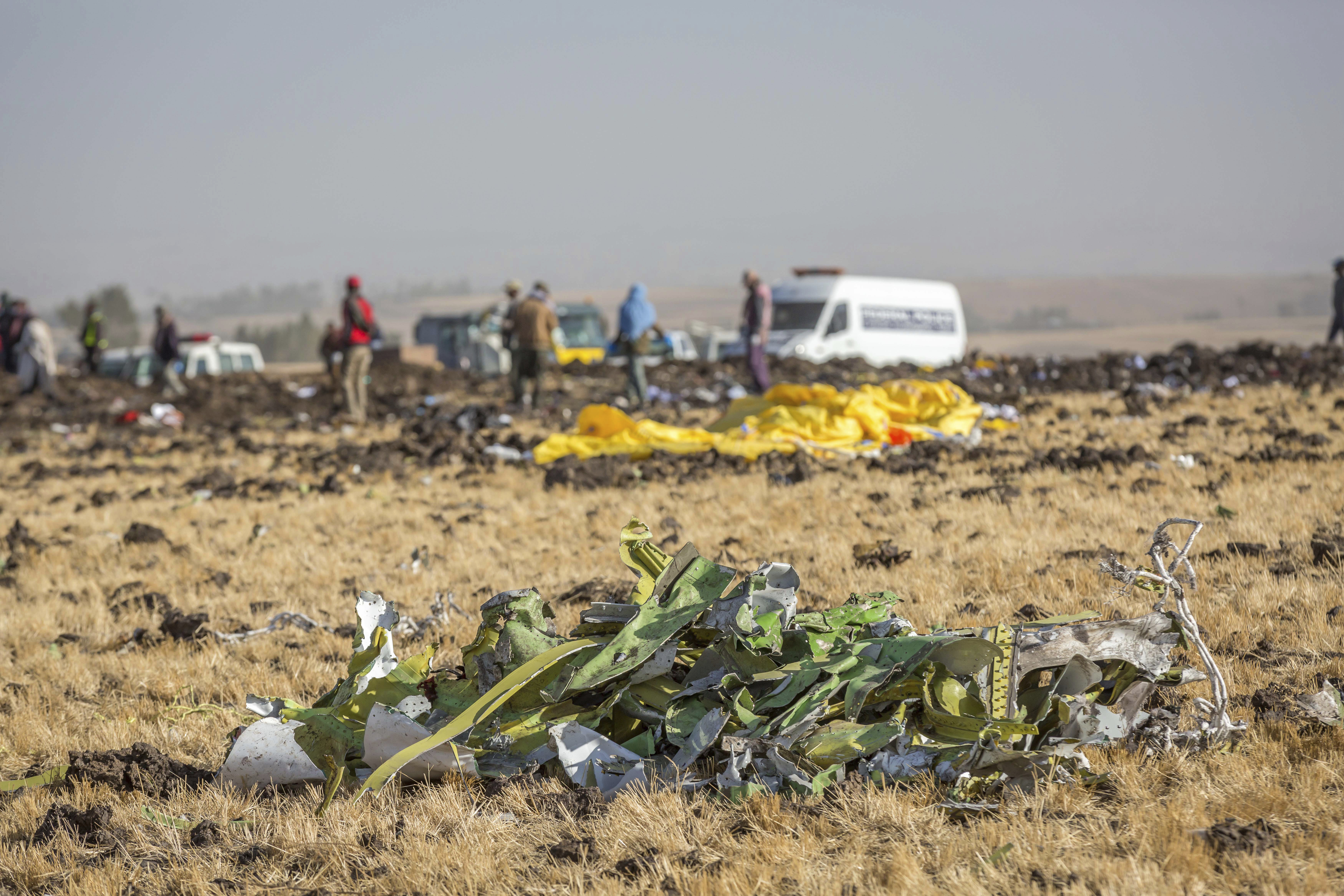 FILE- In this March 11, 2019, file photo parts of the plane wreckage with rescue workers at the crash site at Bishoftu, or Debre Zeit, outside Addis Ababa, Ethiopia. Investigators have determined that an anti-stall system automatically activated before the Ethiopian Airlines Boeing 737 Max jet plunged into the ground, The Wall Street Journal reported Friday, March 29. (AP Photo/Mulugeta Ayene, File)