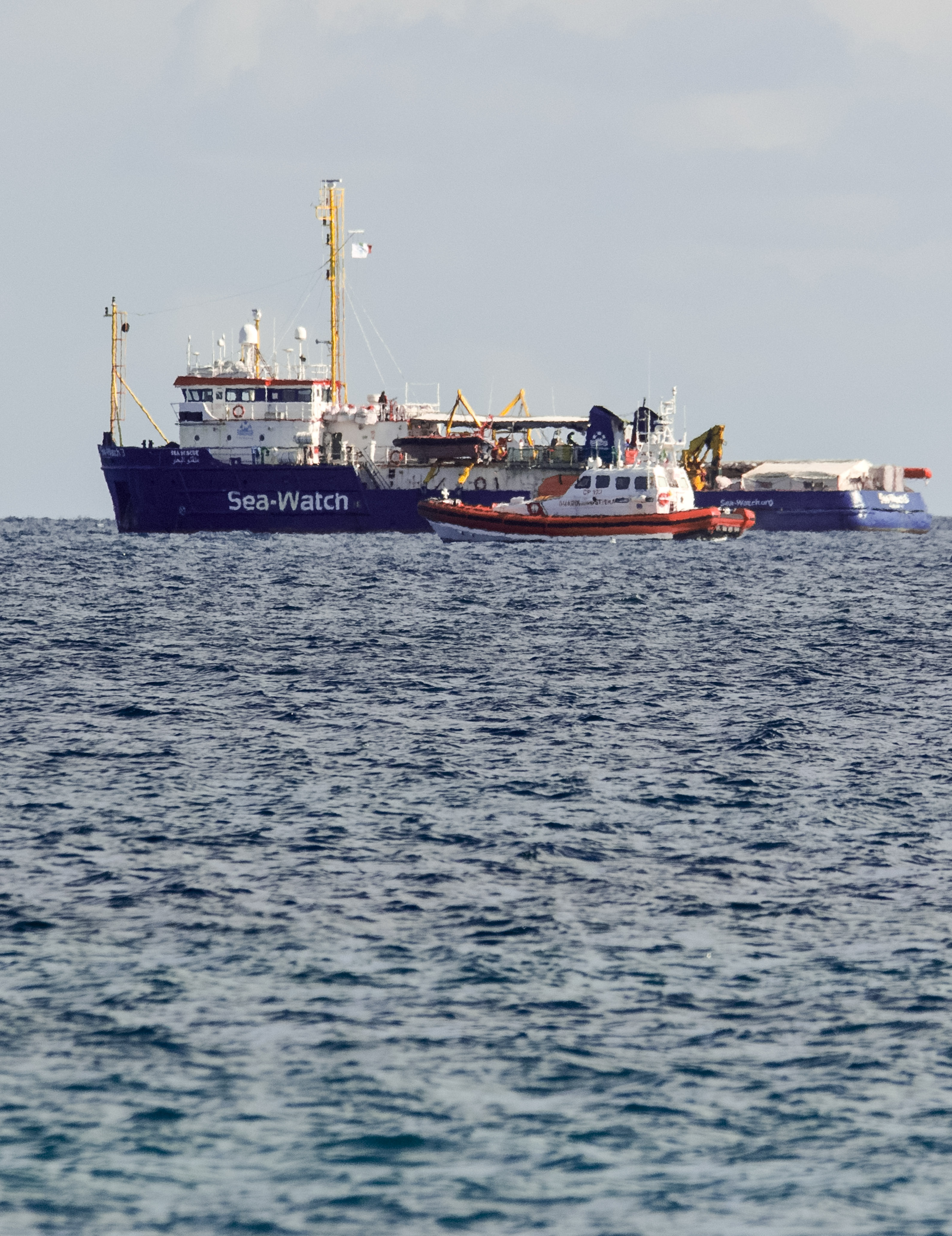 An Italian Coast Guard patroller flanks the Sea-Watch rescue ship off the Sicilian coast where it found shelter, about one nautical mile from Siracusa, from gale winds sweeping the Sicilian Channel, Friday, Jan. 25, 2019. The Sea-Watch is carrying 47 people saved from the sea. Italian Interior minister Salvini yesterday tweeted that the government is An Italian Coast Guard patroller flanks the Sea-Watch rescue ship off the Sicilian coast where it found shelter, about one nautical mile from Siracusa, from gale winds sweeping the Sicilian Channel, Friday, Jan. 25, 2019. The Sea-Watch is carrying 47 people saved from the sea. Italian Interior minister Salvini yesterday tweeted that the government is