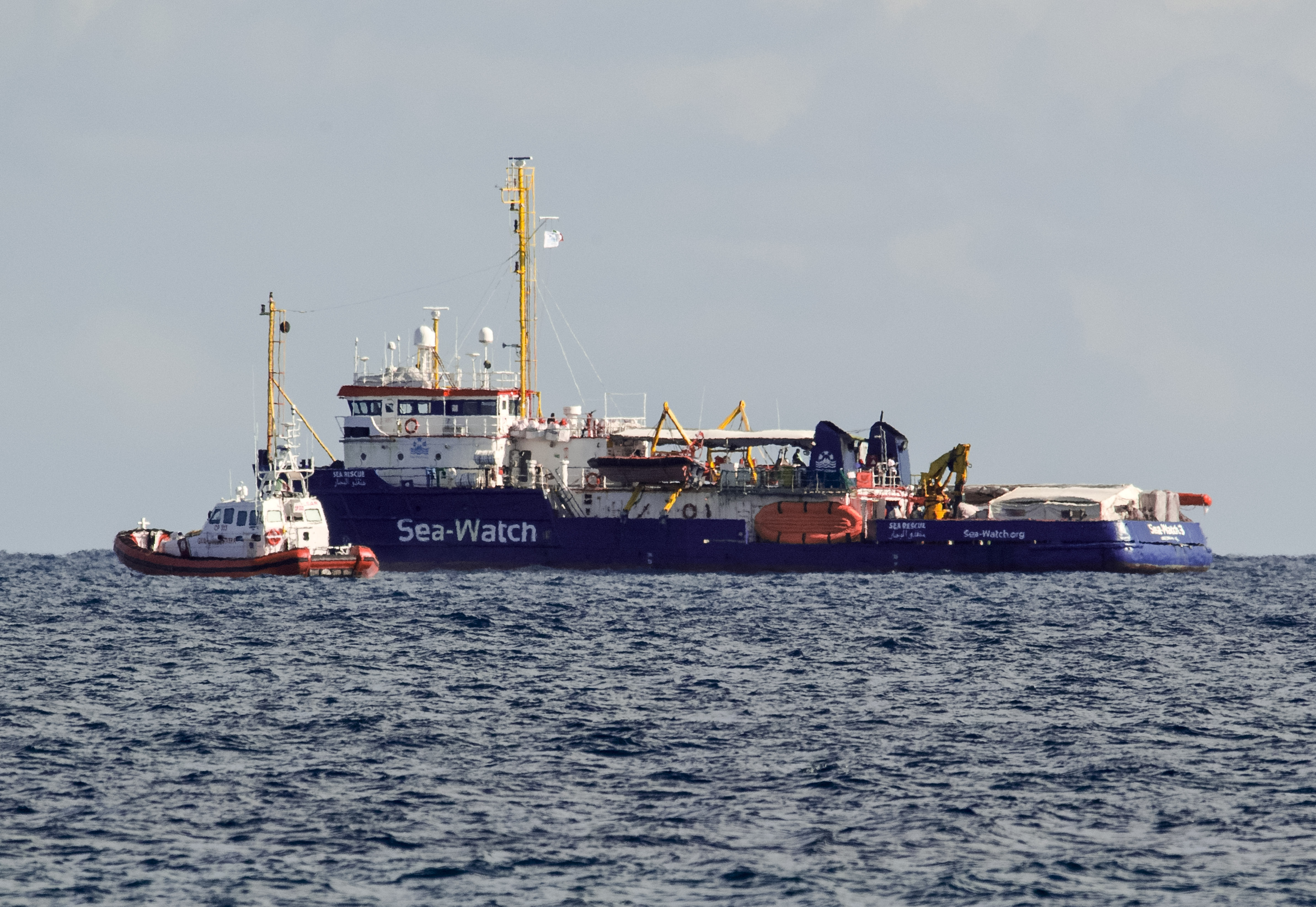 An Italian Coast Guard patroller flanks the Sea-Watch rescue ship off the Sicilian coast where it found shelter, about one nautical mile from Siracusa, from gale winds sweeping the Sicilian Channel, Friday, Jan. 25, 2019. The Sea-Watch is carrying 47 people saved from the sea. Italian Interior minister Salvini yesterday tweeted that the government is An Italian Coast Guard patroller flanks the Sea-Watch rescue ship off the Sicilian coast where it found shelter, about one nautical mile from Siracusa, from gale winds sweeping the Sicilian Channel, Friday, Jan. 25, 2019. The Sea-Watch is carrying 47 people saved from the sea. Italian Interior minister Salvini yesterday tweeted that the government is