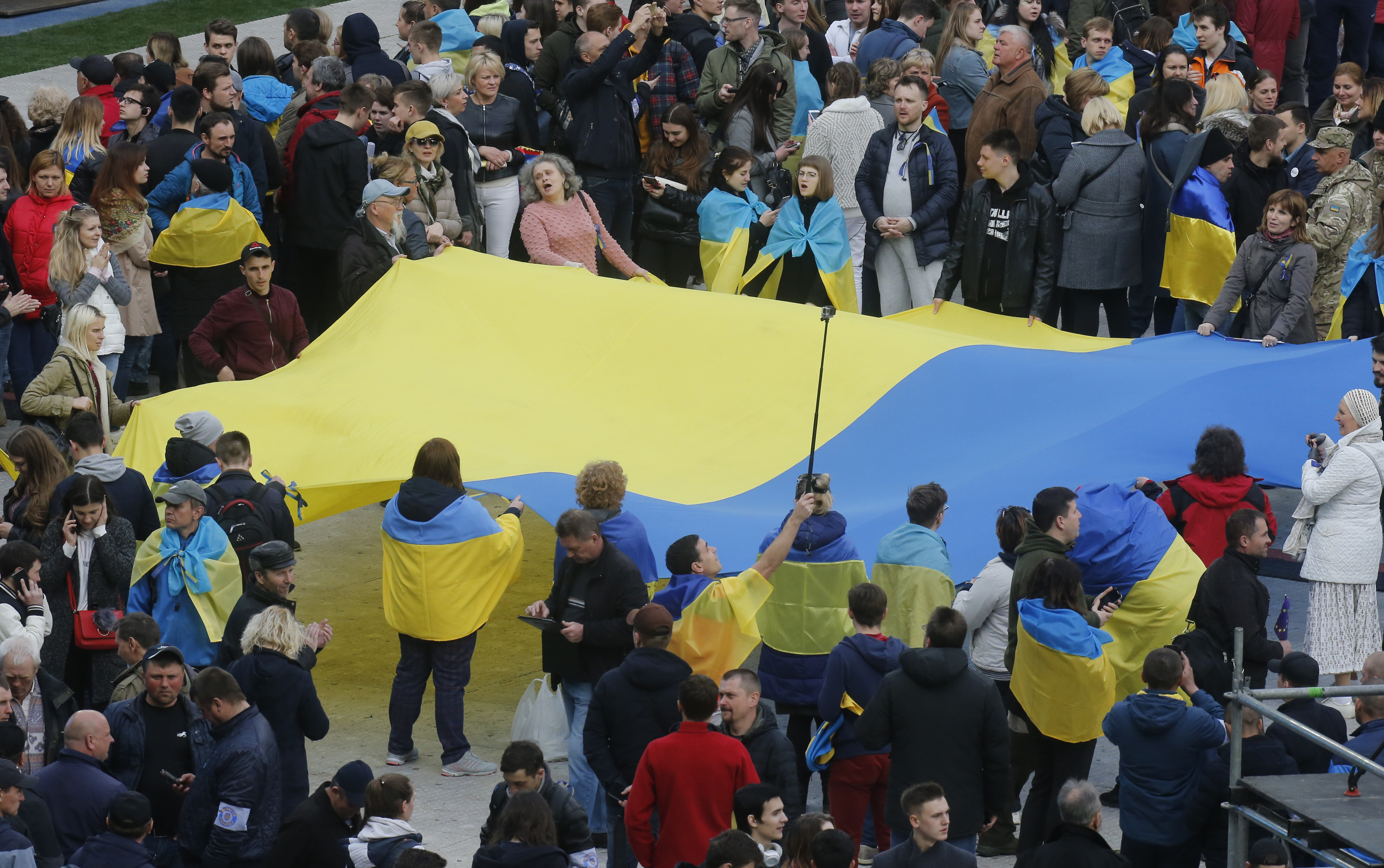 People hold Ukrainian national flag at the Olympic stadium prior debates between two candidates in the weekend presidential run-off in Kiev, Ukraine, Friday, April 19, 2019. Friday is the last official day of election canvassing in Ukraine as all presidential candidates and their campaigns will be barred from campaigning on Saturday, the day before the vote. (AP Photo/Efrem Lukatsky) People hold Ukrainian national flag at the Olympic stadium prior debates between two candidates in the weekend presidential run-off in Kiev, Ukraine, Friday, April 19, 2019. Friday is the last official day of election canvassing in Ukraine as all presidential candidates and their campaigns will be barred from campaigning on Saturday, the day before the vote. (AP Photo/Efrem Lukatsky)