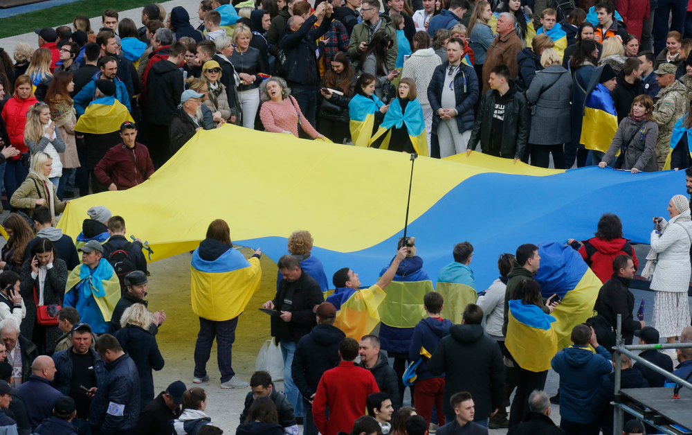 People hold Ukrainian national flag at the Olympic stadium prior debates between two candidates in the weekend presidential run-off in Kiev, Ukraine, Friday, April 19, 2019. Friday is the last official day of election canvassing in Ukraine as all presidential candidates and their campaigns will be barred from campaigning on Saturday, the day before the vote. (AP Photo/Efrem Lukatsky) People hold Ukrainian national flag at the Olympic stadium prior debates between two candidates in the weekend presidential run-off in Kiev, Ukraine, Friday, April 19, 2019. Friday is the last official day of election canvassing in Ukraine as all presidential candidates and their campaigns will be barred from campaigning on Saturday, the day before the vote. (AP Photo/Efrem Lukatsky)