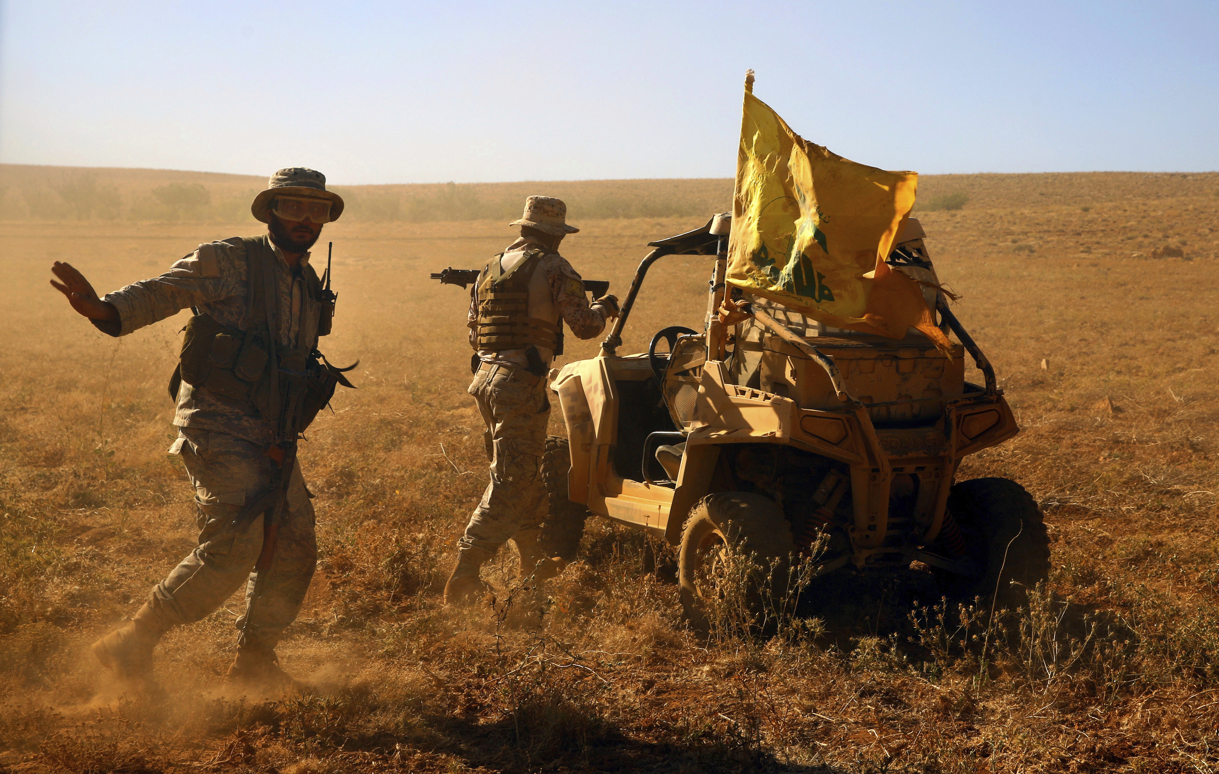 FILE - This July 29, 2017 file photo, Hezbollah fighters stand near a four-wheel motorcycle positioned at the site where clashes erupted between Hezbollah and al-Qaida-linked fighters in Wadi al-Kheil or al-Kheil Valley on the Lebanon-Syria border. The British government will make inciting support for Hezbollah a criminal offense as senior officials accused the Iran-backed organization of destabilizing the Middle East. (AP Photo/Bilal Hussein, File) FILE - This July 29, 2017 file photo, Hezbollah fighters stand near a four-wheel motorcycle positioned at the site where clashes erupted between Hezbollah and al-Qaida-linked fighters in Wadi al-Kheil or al-Kheil Valley on the Lebanon-Syria border. The British government will make inciting support for Hezbollah a criminal offense as senior officials accused the Iran-backed organization of destabilizing the Middle East. (AP Photo/Bilal Hussein, File)