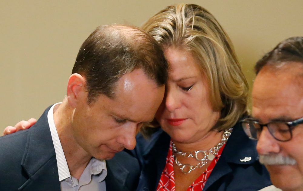 FILE - In this June 27, 2019, file photo, Matthew and Jill McCluskey, parents of Lauren McCluskey, hug after speaking during a news conference in Salt Lake City. The parents of Lauren, a University of Utah student and track athlete who was fatally shot on campus, are fighting a claim by the college that their lawsuit should be dismissed because their daughter's killer wasn't a student. Campus police could have contacted the killer's parole officer or kept him off campus after Lauren and her friends reported his harassment and an extortion attempt, lawyers for Jill and Matthew McCluskey argued in a court filing Monday, Nov. 25. (AP Photo/Rick Bowmer, File) FILE - In this June 27, 2019, file photo, Matthew and Jill McCluskey, parents of Lauren McCluskey, hug after speaking during a news conference in Salt Lake City. The parents of Lauren, a University of Utah student and track athlete who was fatally shot on campus, are fighting a claim by the college that their lawsuit should be dismissed because their daughter's killer wasn't a student. Campus police could have contacted the killer's parole officer or kept him off campus after Lauren and her friends reported his harassment and an extortion attempt, lawyers for Jill and Matthew McCluskey argued in a court filing Monday, Nov. 25. (AP Photo/Rick Bowmer, File)